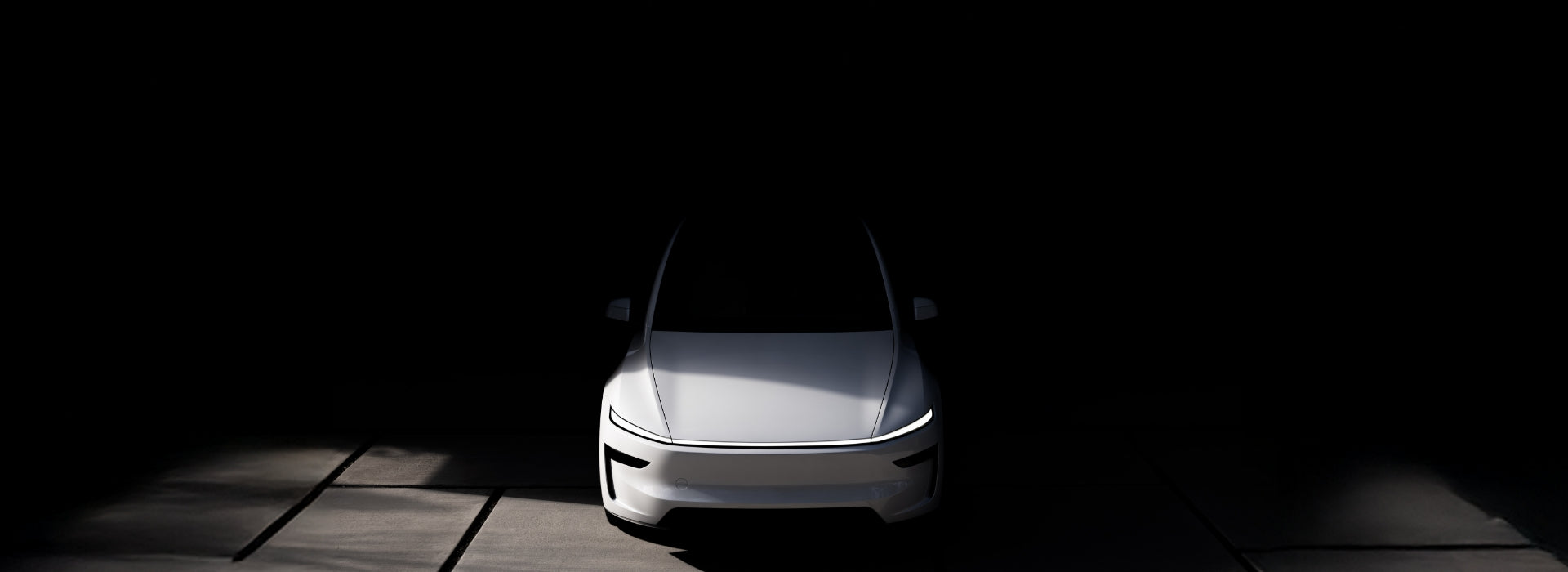 一輛白色的現代電動車在黑暗背景下部分照明,突出了其時尚簡約的前端設計和銳利的 LED 大燈,而周圍環境則仍處於深深的陰影中。.