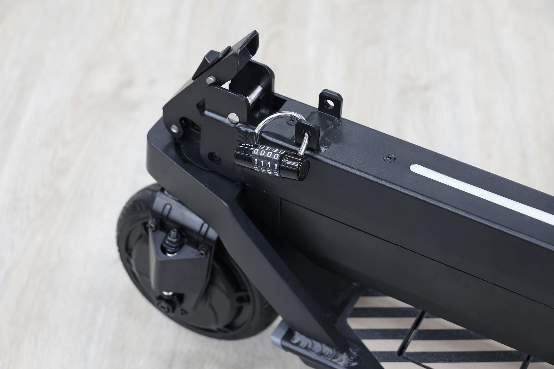 JOWUA Taiwan 折疊電動滑板車|Performance 的特寫,外框上有密碼鎖,突顯其電池容量升級,放置在淺色木地板上。.