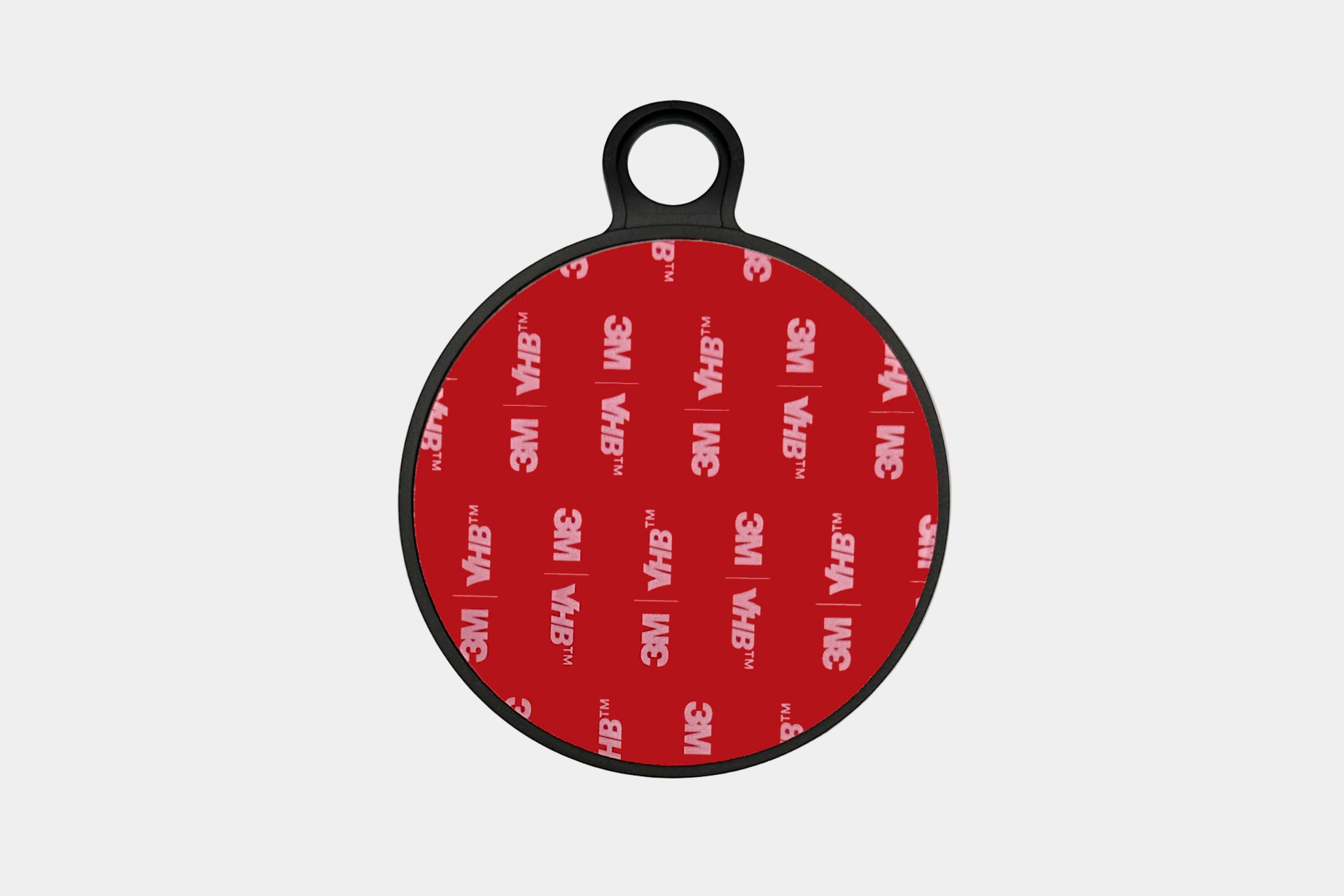 A red circular adhesive pad with the 3M VHB logo in white is affixed to a black plastic round holder with a loop. Perfect for 儀表板無痕安裝, the 儀表板底座(六維隱藏車架專用) looks sleek against a plain white background.