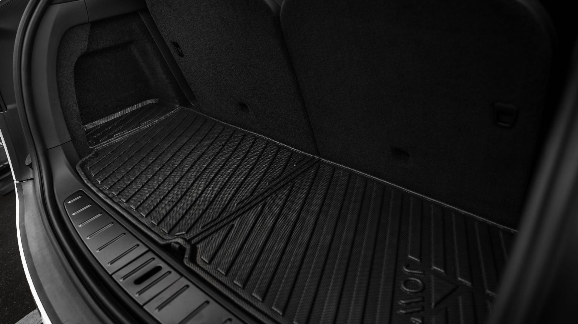 特斯拉 Model X (2021-2025+) 尾箱特寫,已安裝 JOWUA Taiwan 立體防水行李廂墊,並將後座直立。TPE 墊的溝槽可提供抓地力,並防止潑濺、髒污和濕氣。.