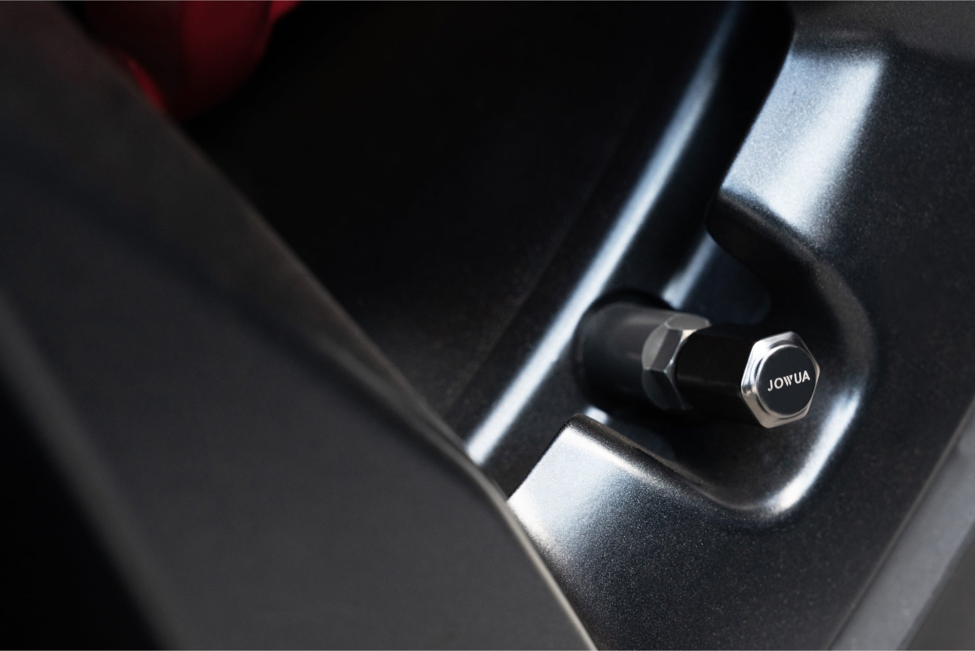 特寫:金屬表面上標有“JOWUA Taiwan”字樣的黑色氣門嘴蓋,類似汽車輪輞,具有柔和的反射,讓人聯想到汽車配件中充氣電組合的高科技感。.