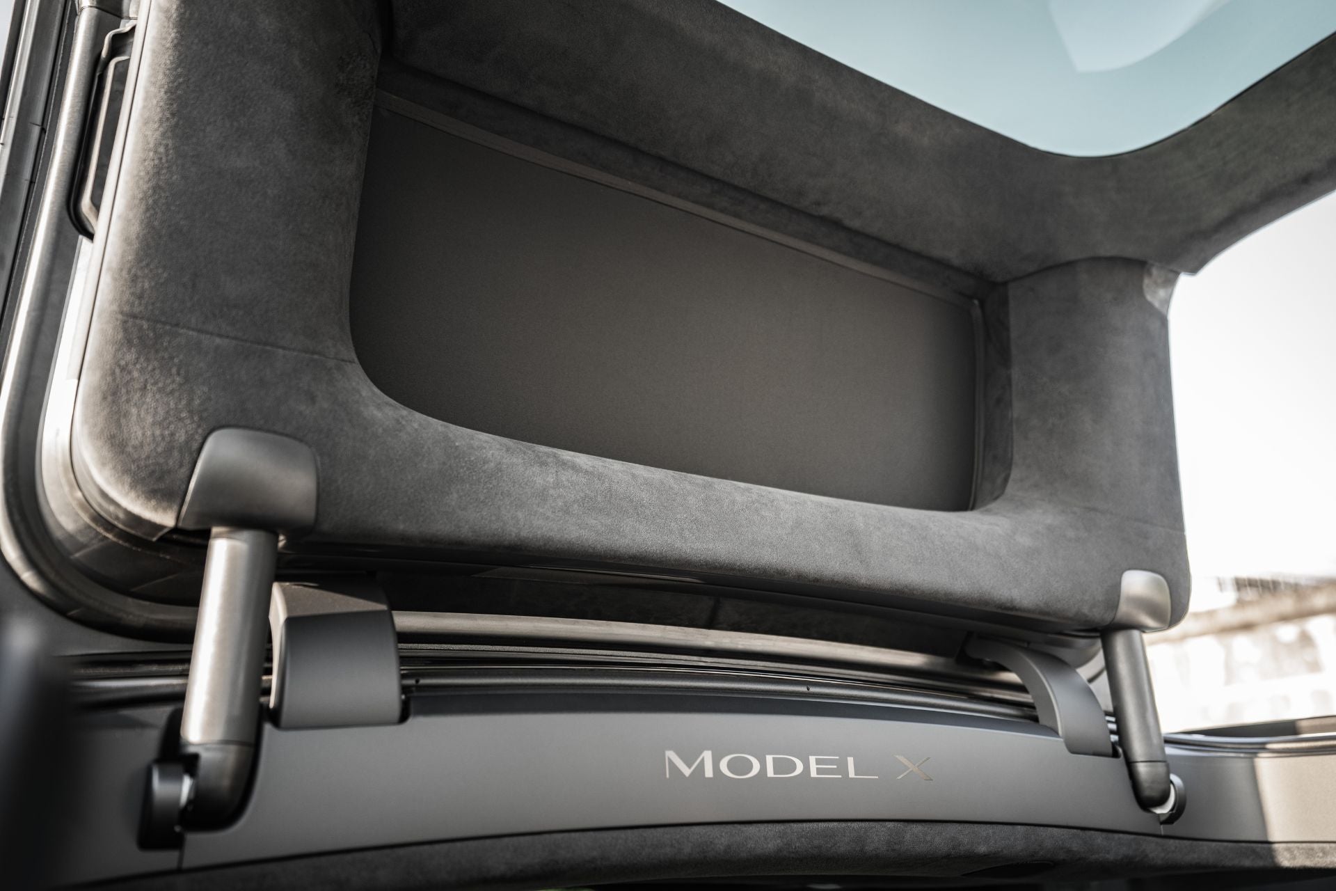 特斯拉 Model X 上安裝的 JOWUA Taiwan 分離式遮陽簾 (Model X) 特寫,可看到打開的鷹翼門專用鷹翼門、金屬面板上的 Model X 標誌,以及上方低調的隔熱車頂。.