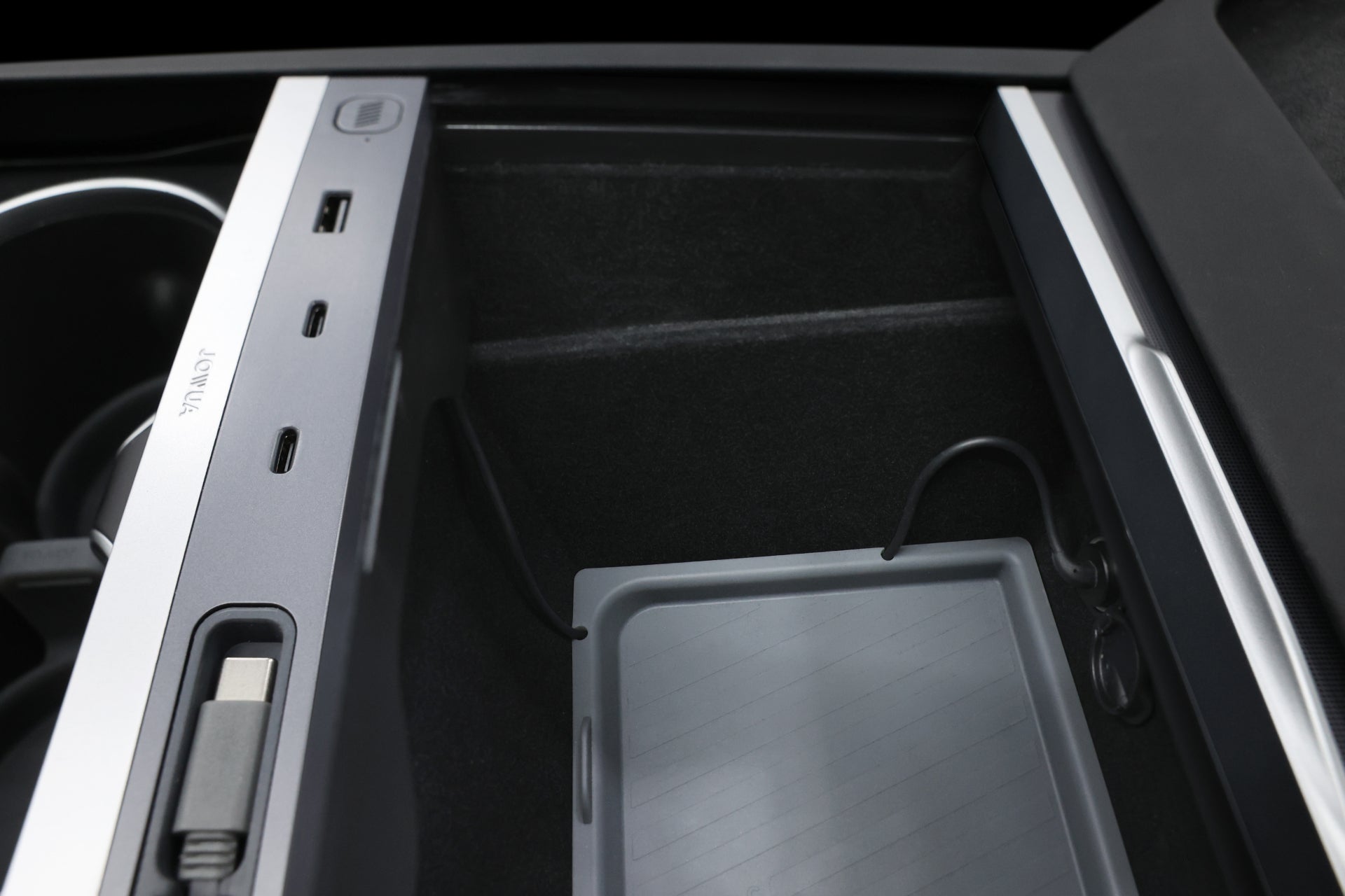JOWUA 台灣 130W LED 集線器(型號 3/Y 煥新版)在儲物箱上方的面板上配備 USB 連接埠、USB-C 連接埠和 12V 插座。可拆卸的托盤和杯架增強了光滑的深色內飾,而快充功能可確保快速充電。.