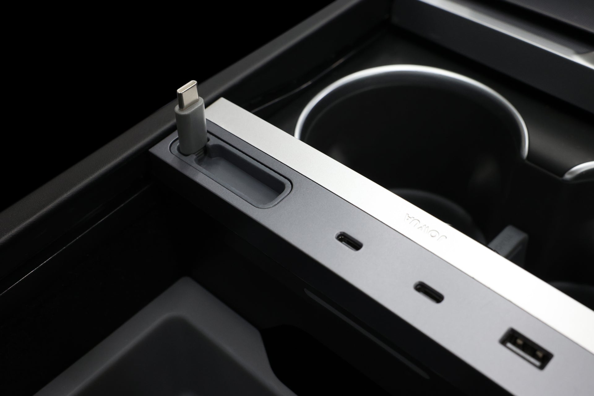 JOWUA 台灣 130W LED 集線器(Model 3/Y 煥新版)內部控制台特寫,配備 USB-C 連接埠和插槽,可用於快速充電或連接。旁邊的便利杯架增強了現代金屬飾面的質感。.