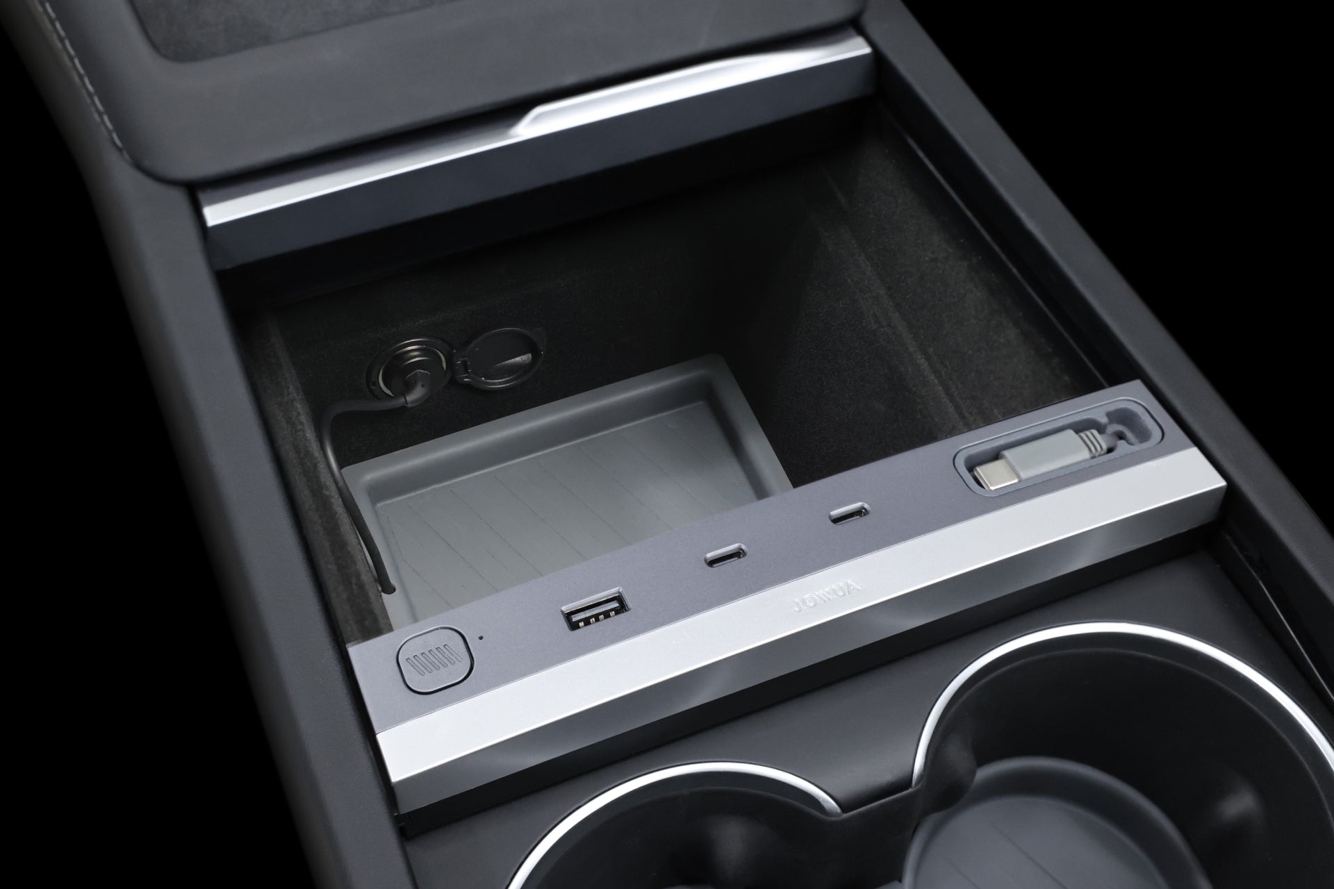 特寫 Model 3/Y 煥新版的 JOWUA 台灣 130W LED 集線器中央控制台,顯示帶有 USB 連接埠的嵌入式隔間、兩個杯架和一個帶滑動蓋的小型儲物區。帶有附加端口和快充功能的拉絲金屬條提供了時尚、現代的設計。.