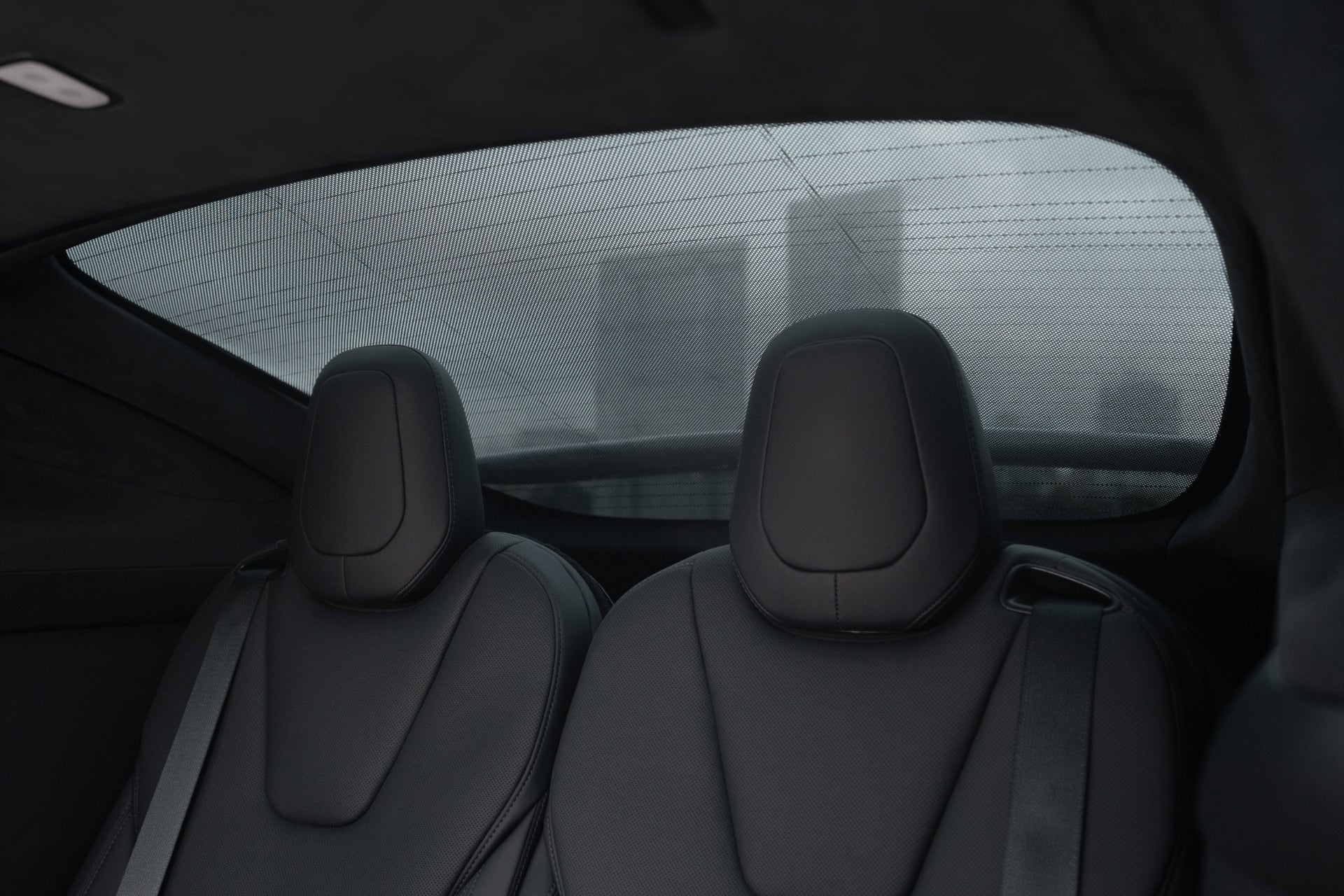 2021+ 年 Model X 的內飾,配備兩個時尚、現代的深色座椅。後窗採用JOWUA台灣尾門+三角窗遮陽簾,擁有紫外線遮蔽保護及增強隔熱效果,可呈現雨天模糊城市景觀。.