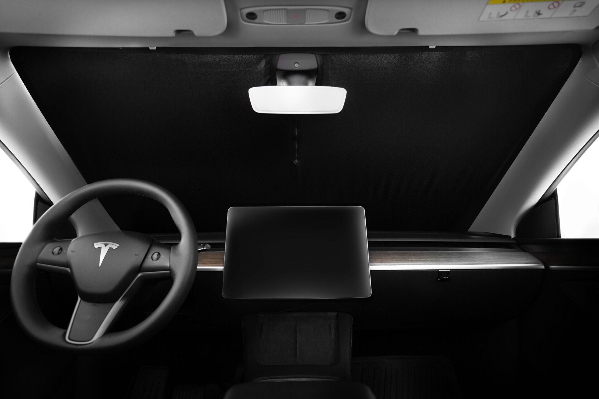 特斯拉 Model Y(2021-2024)內部視圖,採用 JOWUA 台灣全車系極遮陽組件覆蓋擋風玻璃,突出方向盤、大型中央觸控螢幕、後視鏡和簡約的儀表板設計。.