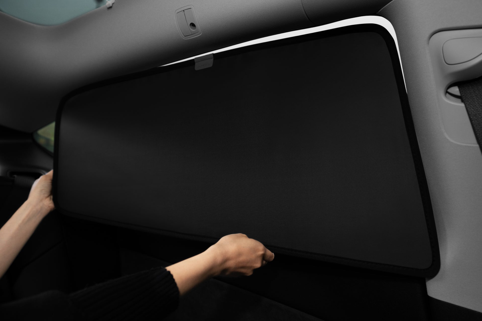 使用雙手將 JOWUA Taiwan 全車終極遮陽組合 (Model Y 煥新版 2025+/2021-2024) 安裝於後車窗,可有效抗 UV 防曬,是必備的特斯拉配件之一。.