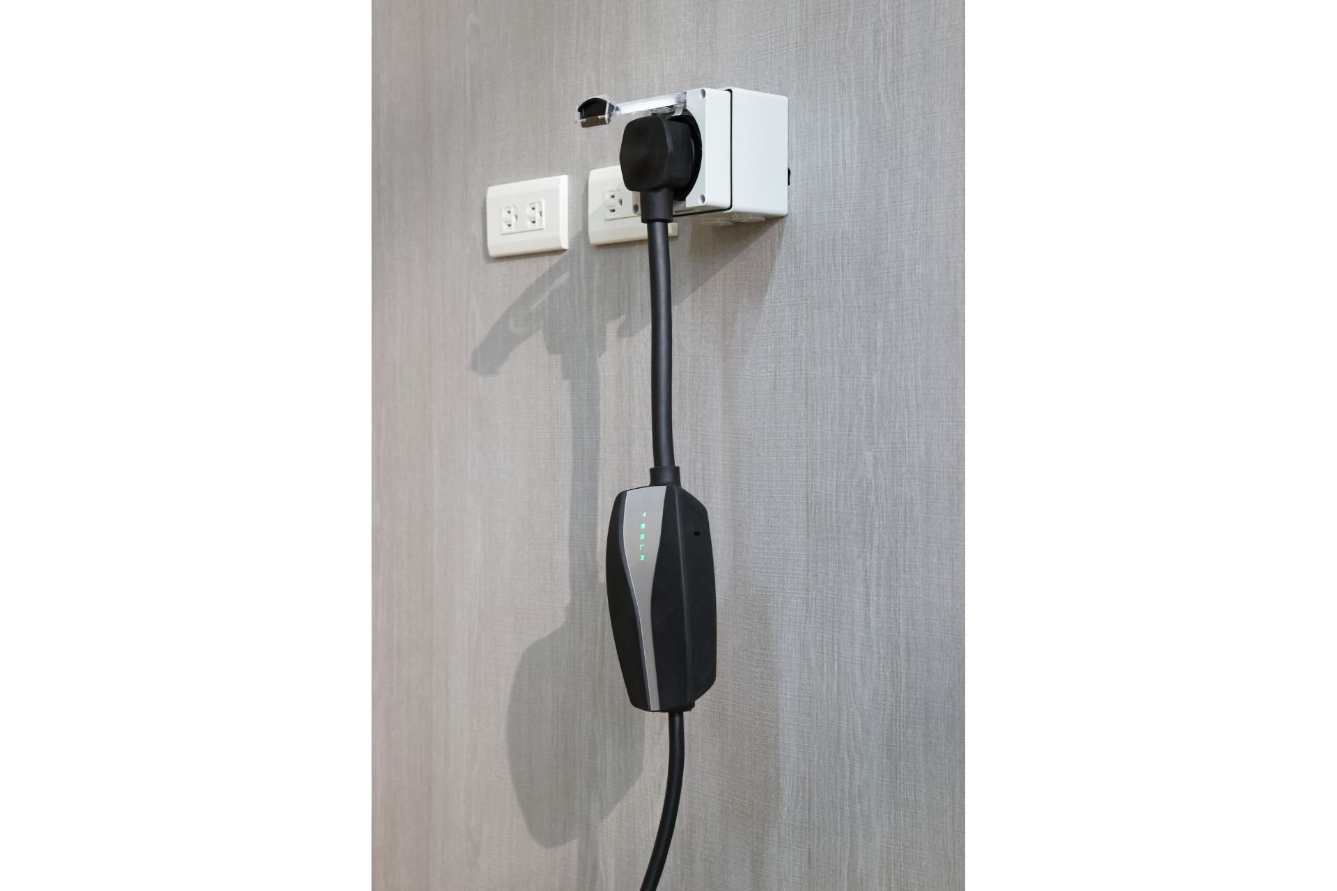 JOWUA 台灣 NEMA 14-50 防水電源插座盒是一款時尚的灰色壁掛式電動車充電器,配有電纜,具有四個發光指示燈。它提供 IP66 防水保護,透過 NEMA 14-50 插頭連接,並通過 ETL 認證,確保安全可靠。.