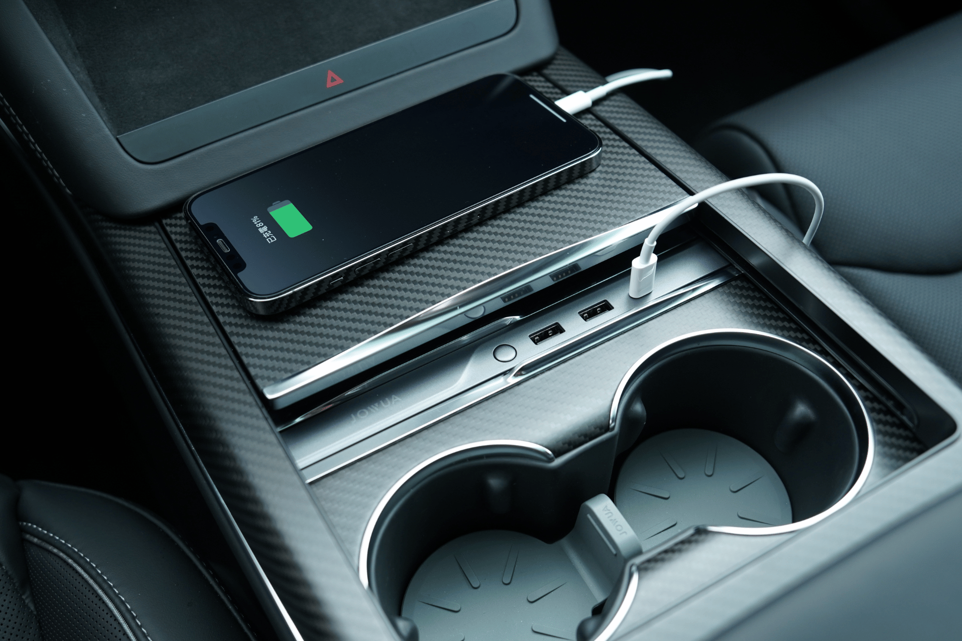 智慧型手機可透過連接線在 JOWUA Taiwan LED HUB for Tesla Model S/X 上充電,此 LED HUB 具備 27W PD 快速充電、USB 連接埠,以及杯座旁的中控台防水儲物空間,方便又安全。.