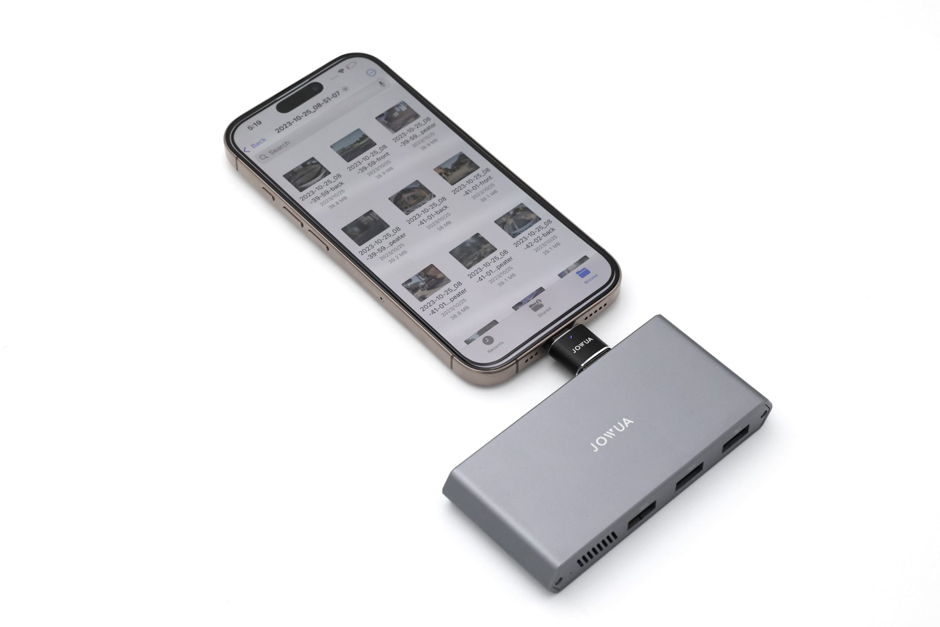 智慧型手機透過轉接頭連接 JOWUA Taiwan Tesla 專用 1 TB SSD+3 Port HUB,顯示檔案管理應用程式。Model S/X/Model 3/Y煥新版/Cybertruck專用USB擴充集線器放置於白色表面。.