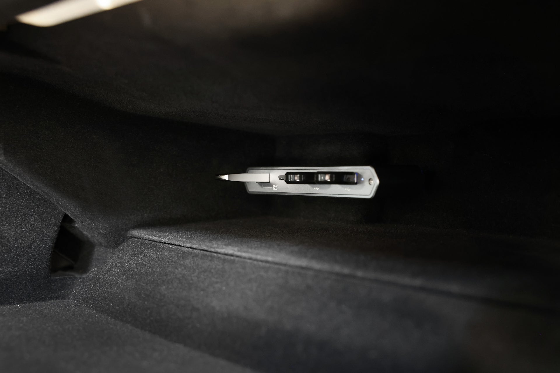 JOWUA Taiwan Tesla雙用儲存HUB (讀卡器及原廠USB) 安裝於手套箱的特寫,四周為深色紋理面板及可見的USB擴充連接埠。相容於 Model S/X/3/Y煥新版及Cybertruck。.