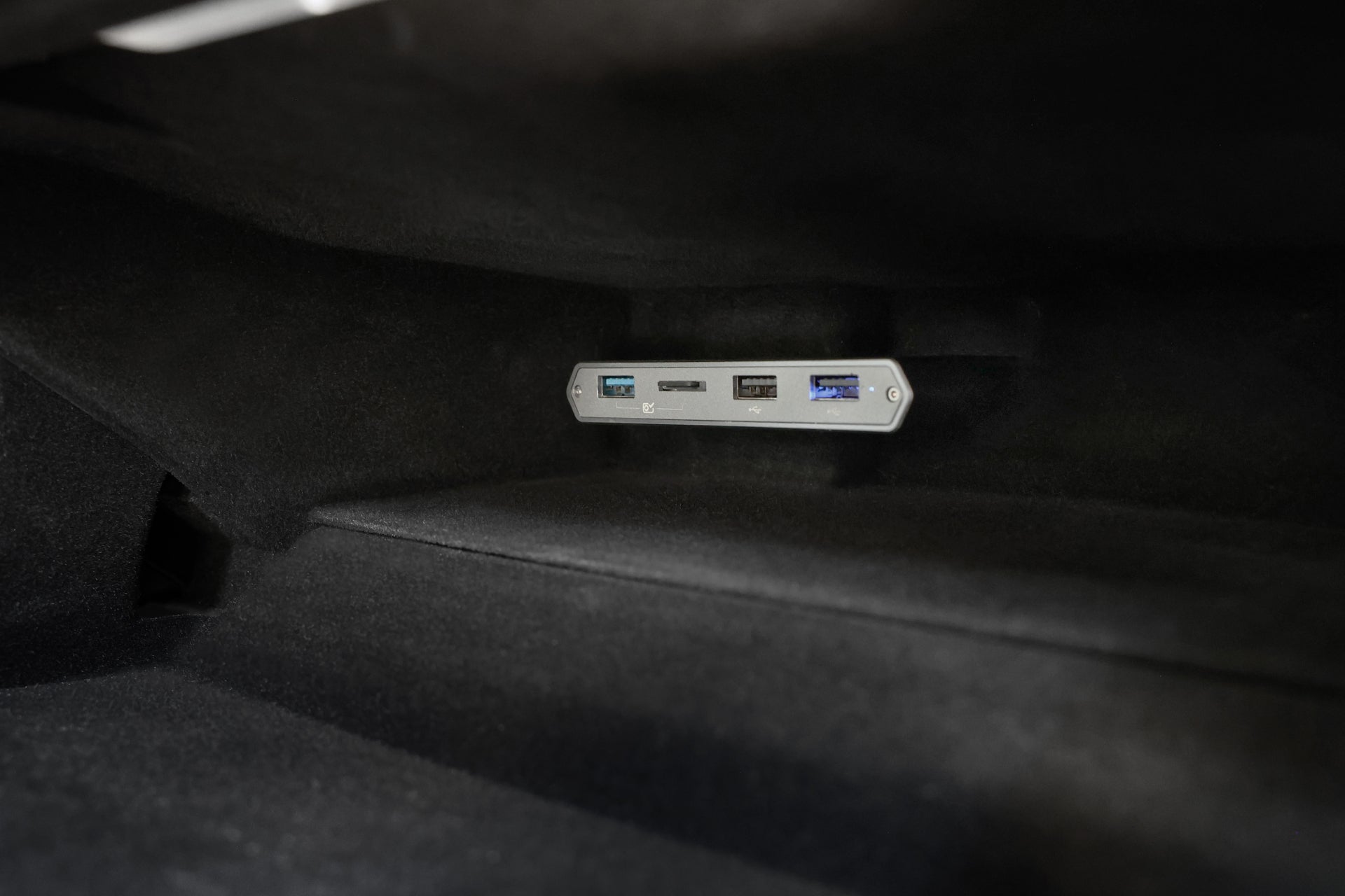 特寫顯示 JOWUA Taiwan 的 Tesla 雙用儲存 HUB (Model S/X/Model 3/Y煥新版/Cybertruck),HW4.0 面板上有 USB、USB-C 和 SD 卡插槽,在光滑的深色內飾中提供 USB 便利擴充。.