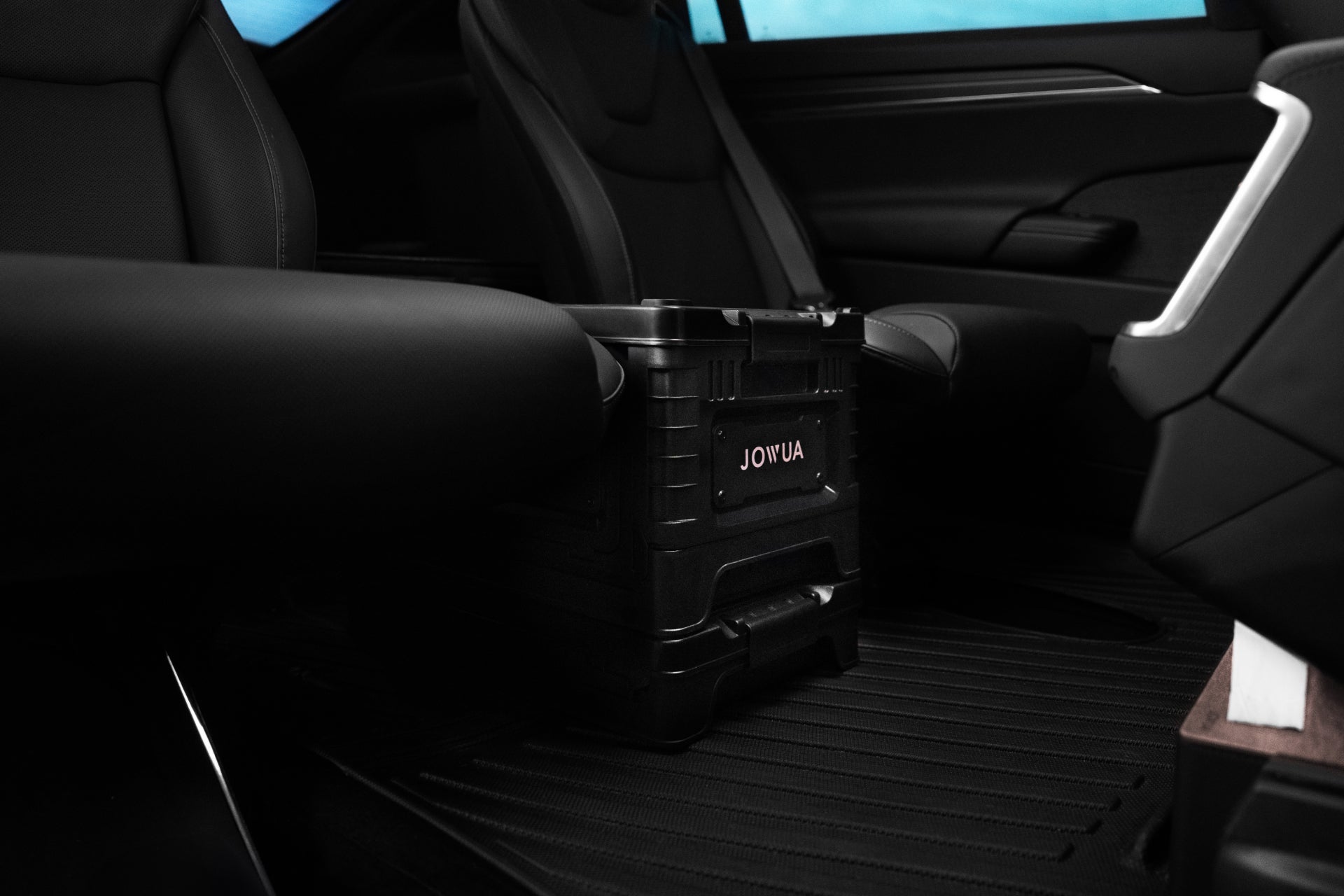 Model X 的內部設有兩個黑色座椅,座椅之間的地板上有一個由 JOWUA 台灣製造的時尚 30L 收納箱。現代化的設計與窗外的藍天全景相結合,營造出魔術大空間的體驗。.