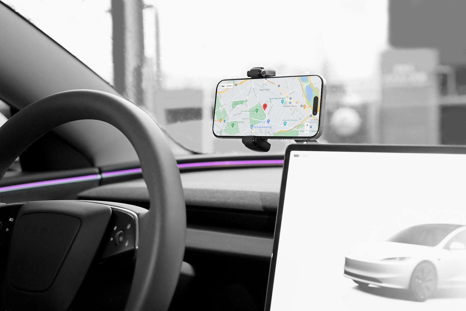 在車內,汽車的儀錶板上有一個顯示地圖的智慧型手機,由 JOWUA 台灣六維隱藏車架(滾輪款)安全地固定。方向盤和帶有汽車輪廓的數位顯示器清晰可見,而擋風玻璃則呈現出柔和模糊的城市景觀。.