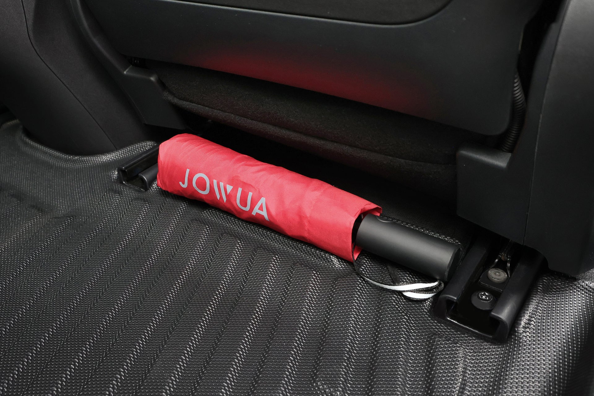 紅色 JOWUA Taiwan 傘子收納在汽車座椅下的立體防水腳踏墊 (Foxtron Bria),專利止擋收納設計,收納安全又方便。.