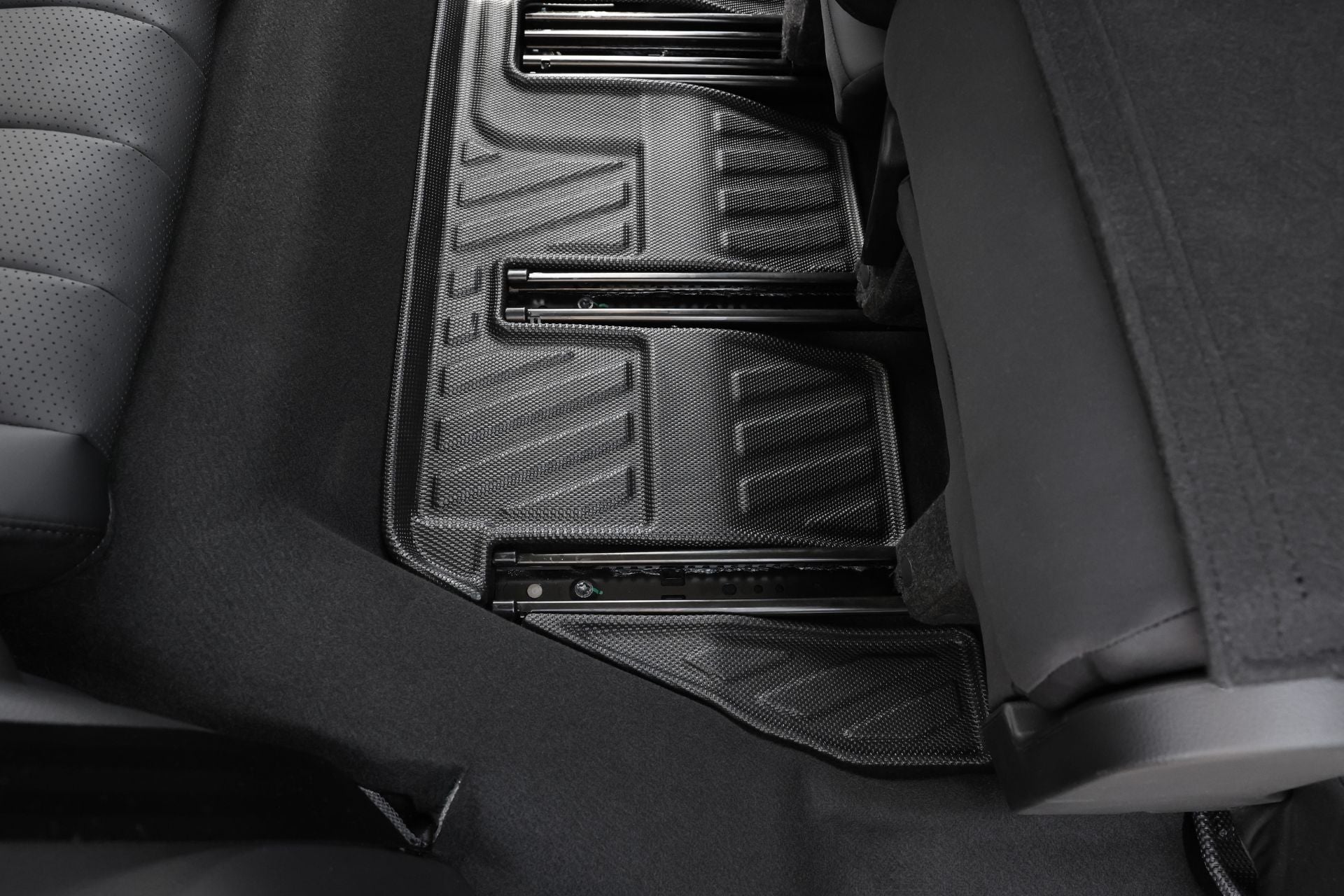 LUXGEN n⁷ 內裝特寫,後地板採用了 JOWUA 台灣的黑色、紋理、立體防水腳踏墊。右側可以部分看到後座。它具有椅下出風口保護網以增加保護,非常適合納智捷LUXGEN的風格。.