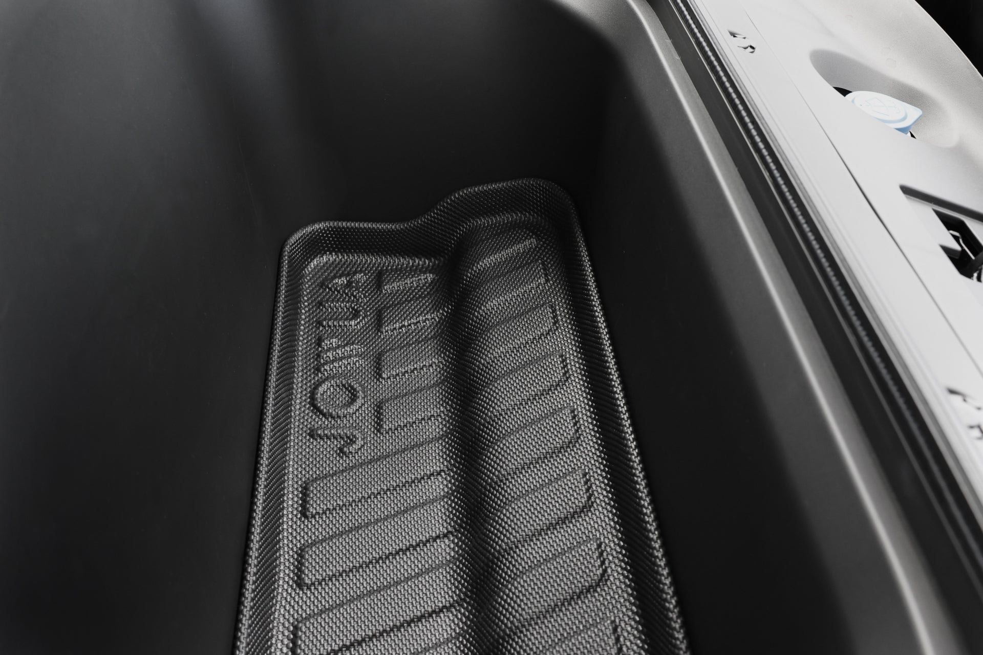 黑色 JOWUA Taiwan 立體防水行李廂墊+椅背墊組合 (LUXGEN n⁷ 7人座) 的空車行李廂特寫;「FRUNK」壓印在 TPE 表面,表面光滑且呈深色。.