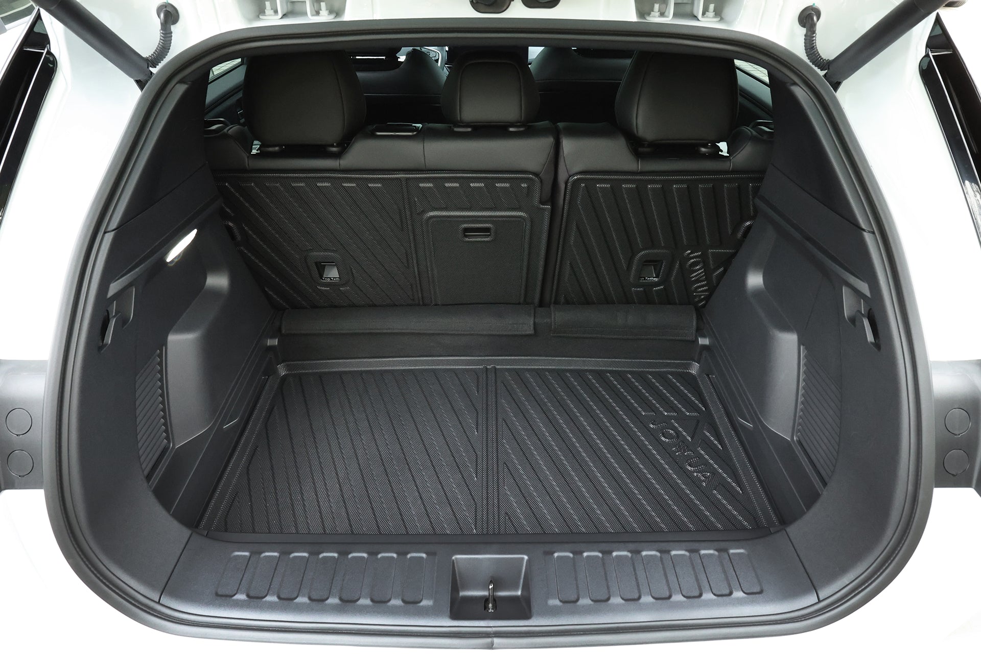 一輛白色休旅車的開放式後車廂,寬敞整潔的載貨區配備黑色襯裡及可摺疊的後排座椅,並由 JOWUA 台灣立體防水行李廂墊+椅背墊組合 (Foxtron Bria) 提供質感抓地力及防水保護。看不到任何物品。.