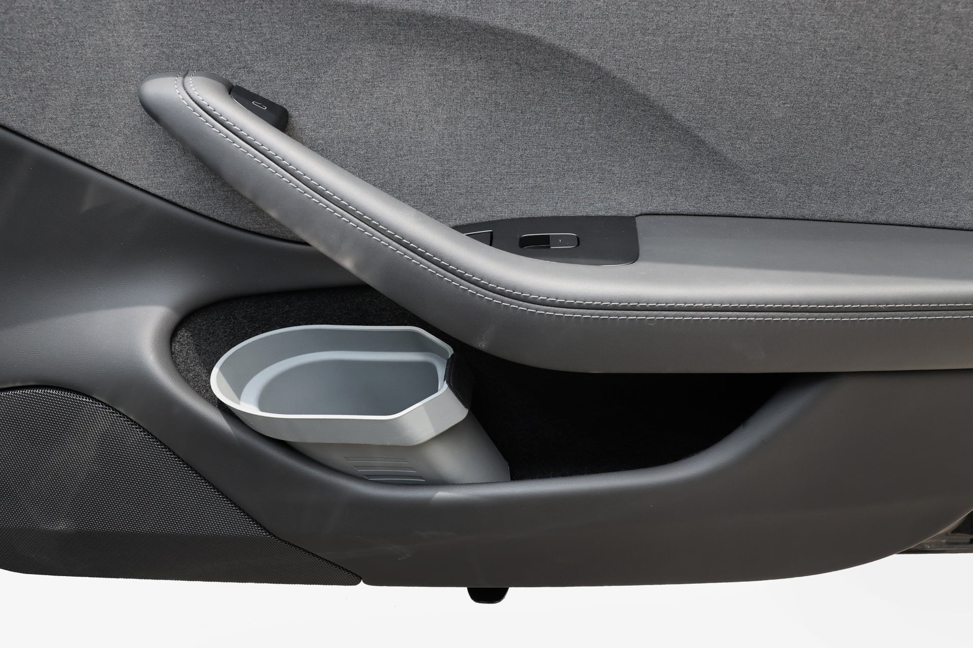 車內門採用弧形把手、灰色矩形垃圾箱,並採用灰色織物和黑色裝飾的時尚設計。 JOWUA Taiwan 車內萬用收納桶(兩入一組)的加入,提供最佳的收納解決方案。.