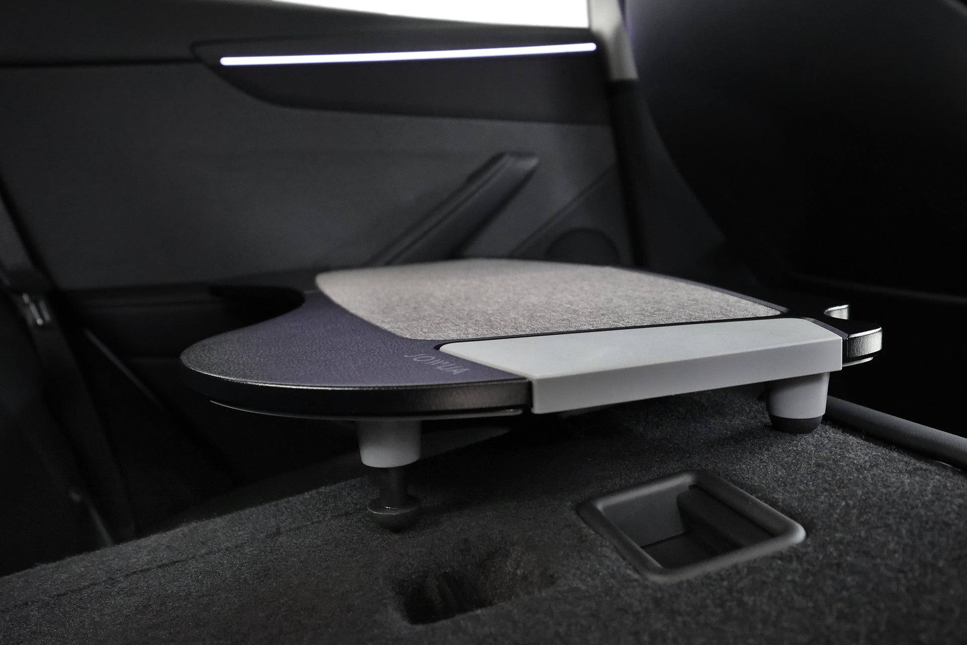 安裝在現代汽車後座上的 JOWUA 台灣車用折疊桌板兩入組的特寫,突出了智慧車內收納功能和時尚的黑灰色內裝。.