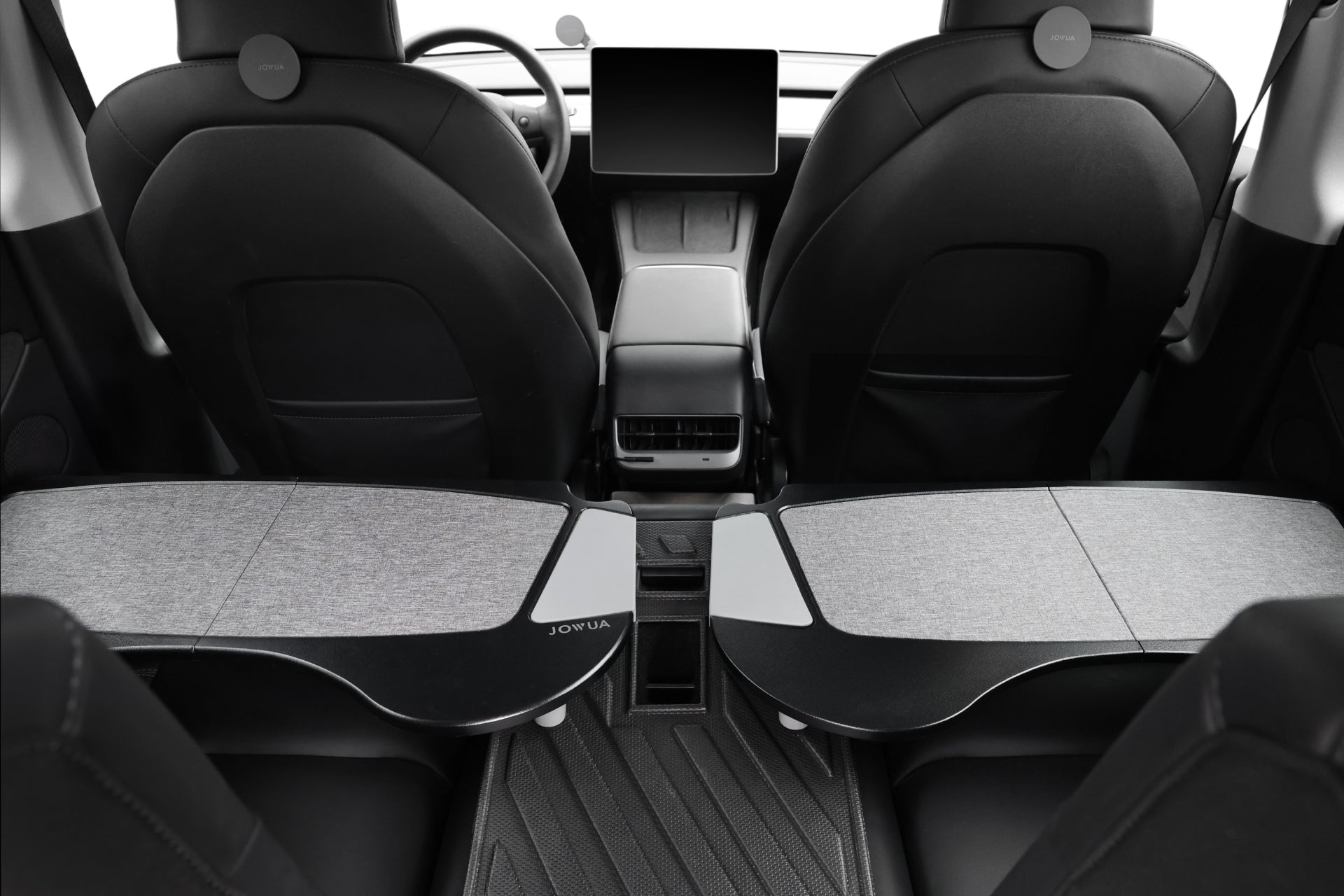 Tesla 內裝的後視圖顯示兩個前排座椅,附有 JOWUA 台灣車用折疊桌板兩入組托盤,形成實用的辦公室工作區或用餐區,以及中央觸控螢幕顯示器。.