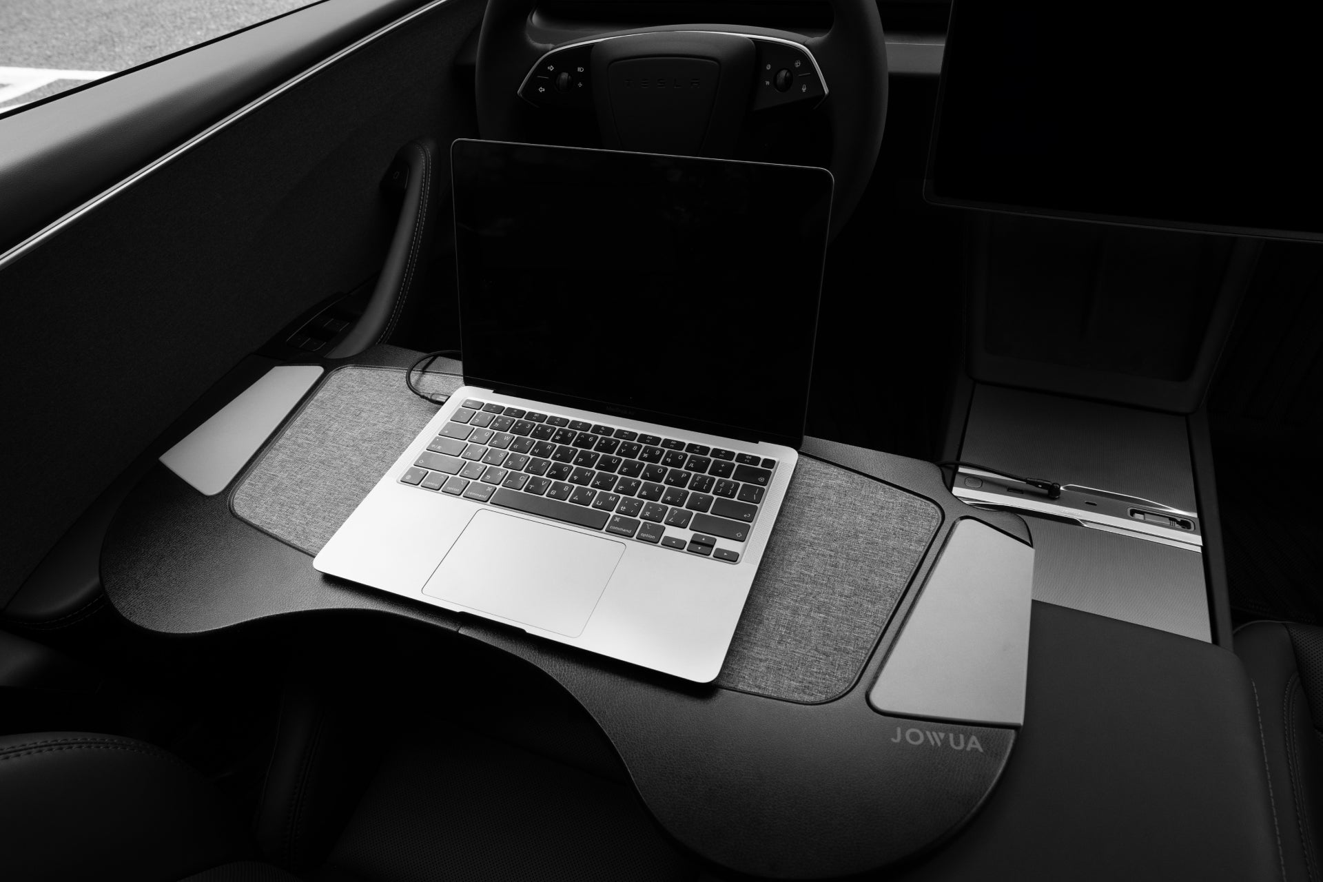 JOWUA台灣車用折疊桌板兩入組(適用Model Y煥新版2025+/Model 3 2018-2023 & Model Y 2021-2024)置於車內,形成一個方便的行動辦公室,方向盤和儀錶板盡收眼底。.