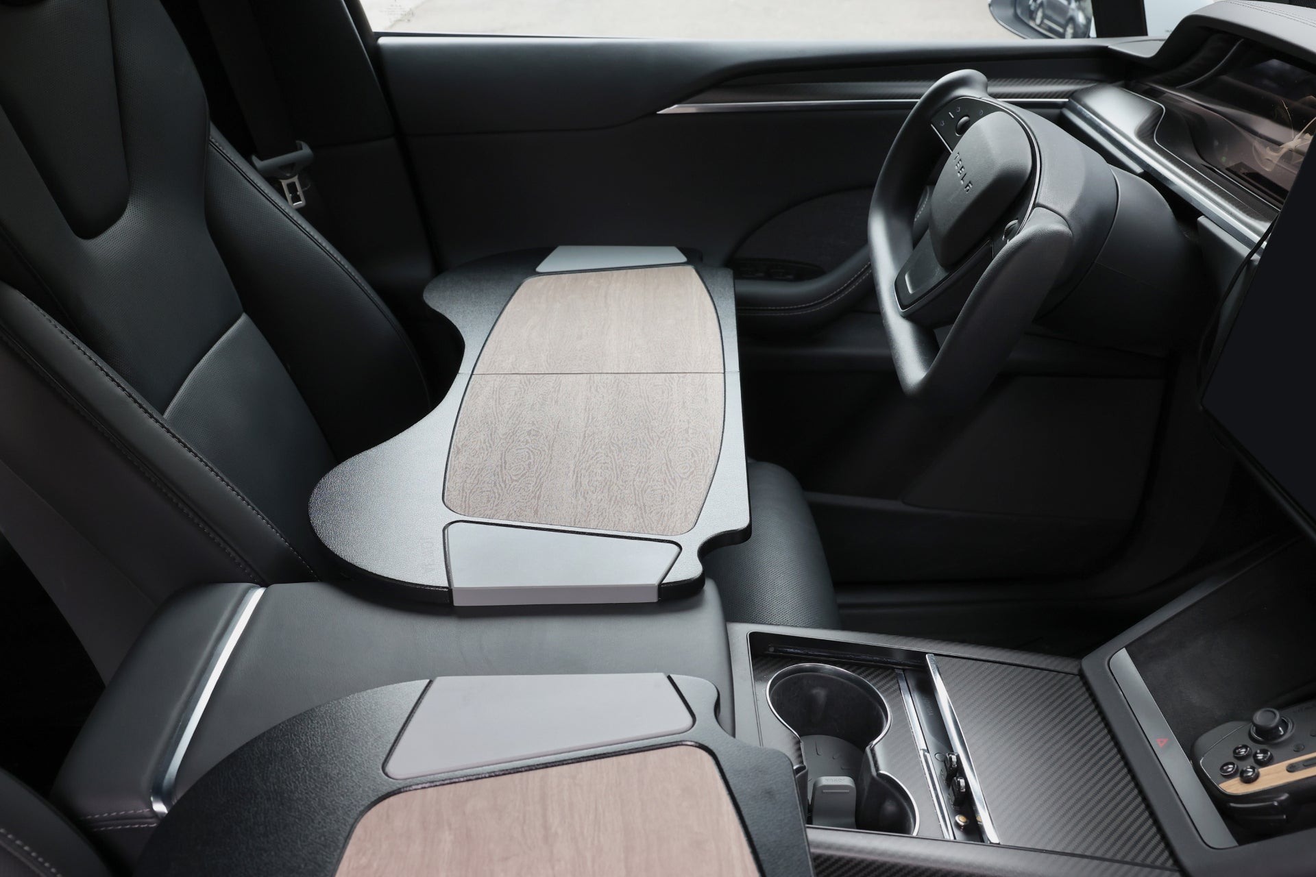 Tesla 汽車內裝採用 JOWUA 台灣車用折疊桌板,設計時尚、現代,配有精緻的木材和皮革飾面。這個理想的行動辦公室包括駕駛座椅和方向盤,中央控制台上有一個杯架,以及方便使用的大型儀表板顯示器。.
