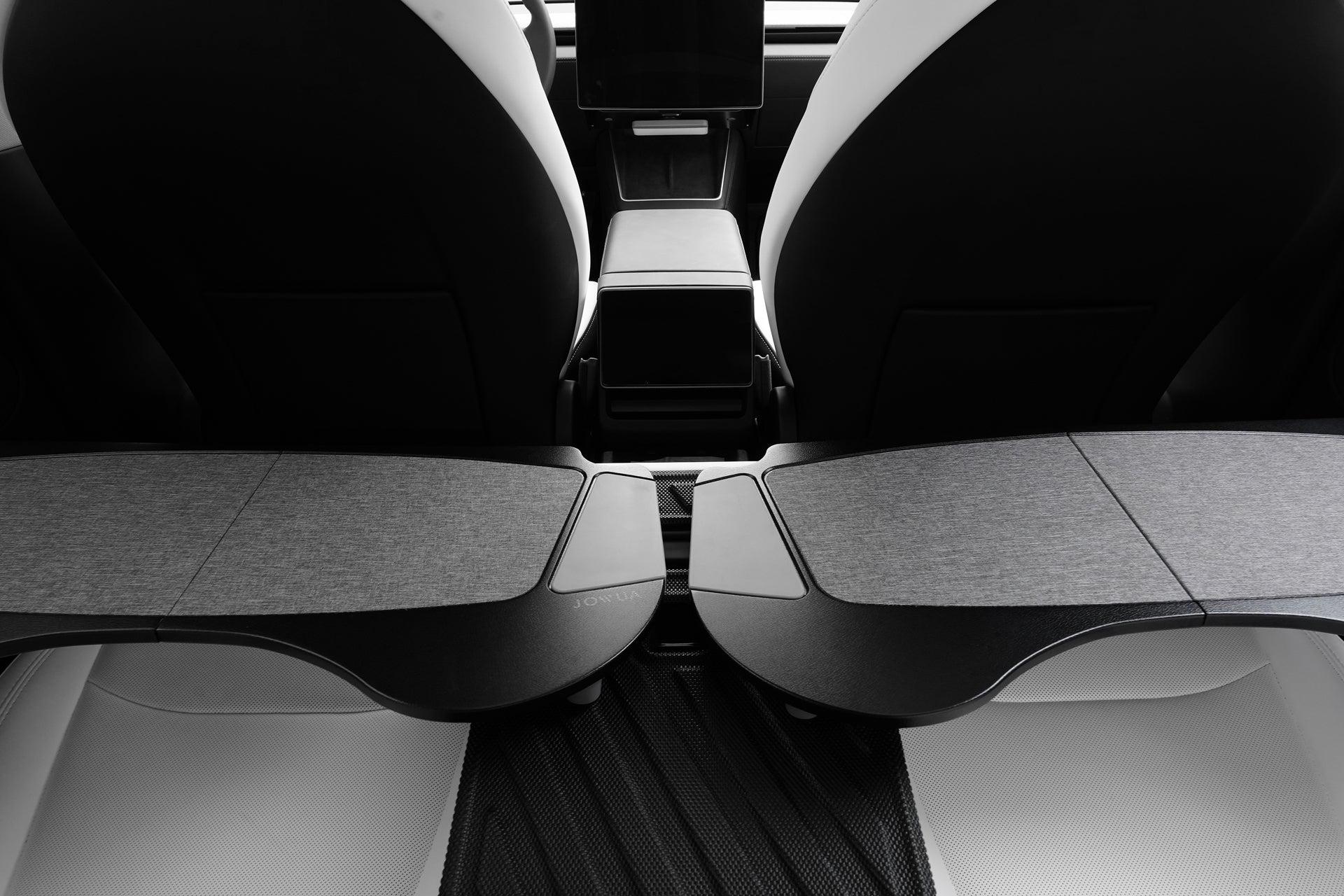 現代汽車的後座視圖展示了 JOWUA 台灣車用折疊桌板,座椅靠背採用時尚的黑色和灰色折疊式設計(折疊式設計),前儀表板附近還配有數位顯示器。.