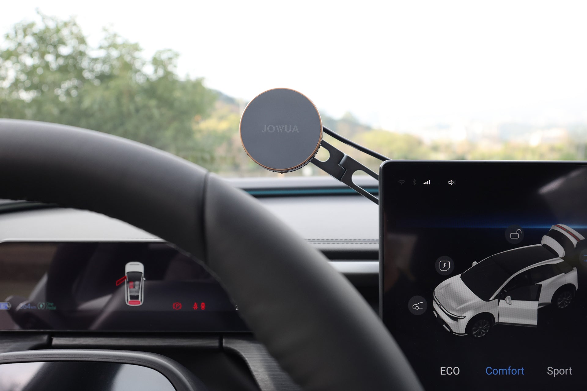 汽車儀表板特寫,顯示 JOWUA 台灣製冷六維隱藏車架 (MagSafe 款) 配備 MagSafe 磁吸無線充電和 Qi2 製冷雙降溫的手機支架,旁邊是 ECO、Comfort 和 Sport 駕駛模式的控制鈕。.