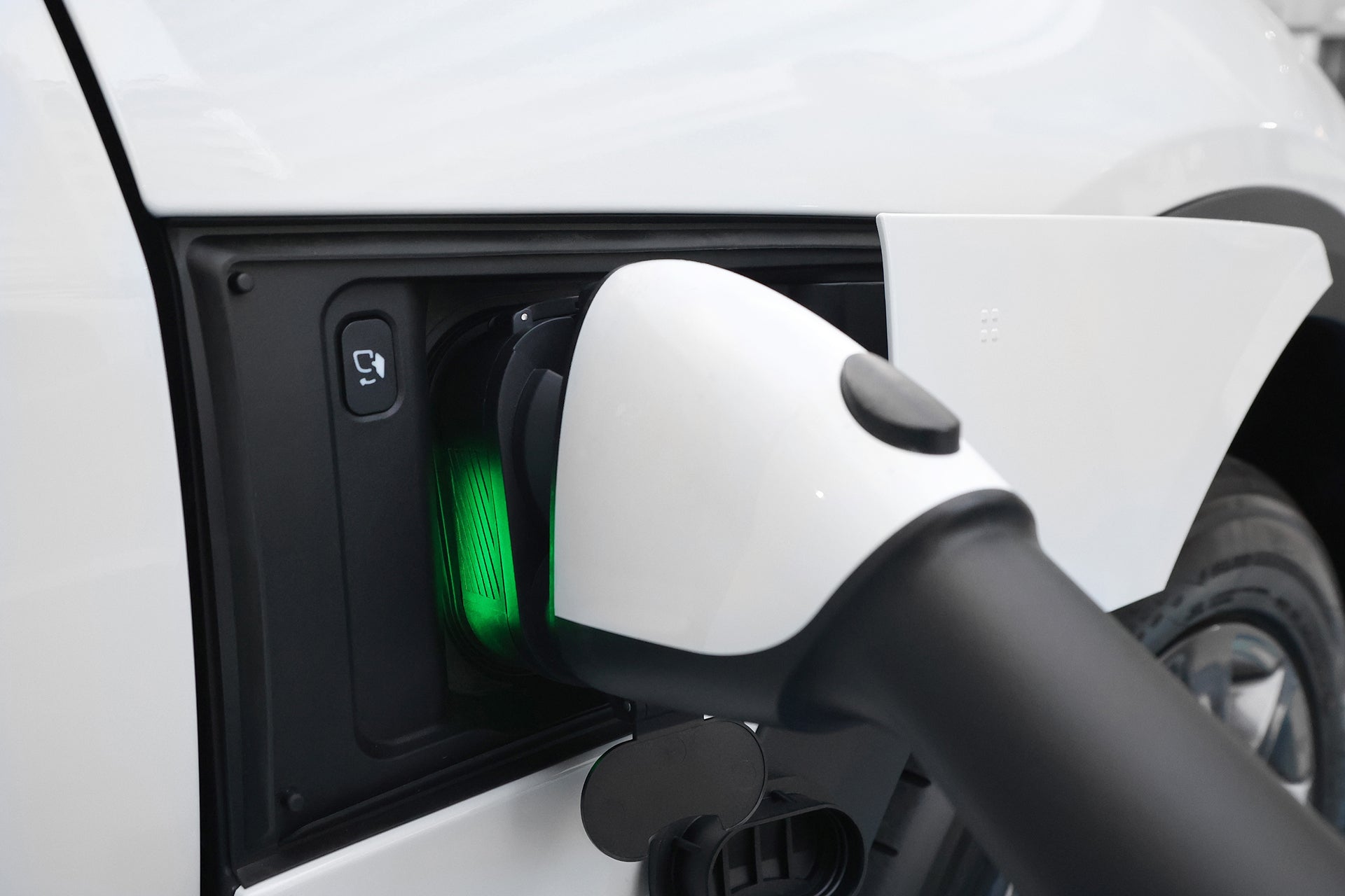 一張正在充電的 Audi Q6 特寫照片顯示 JOWUA Taiwan CCS1 to CCS2 DC & AC 快慢充萬用組,白色插頭已連接,綠燈顯示正在充電。.