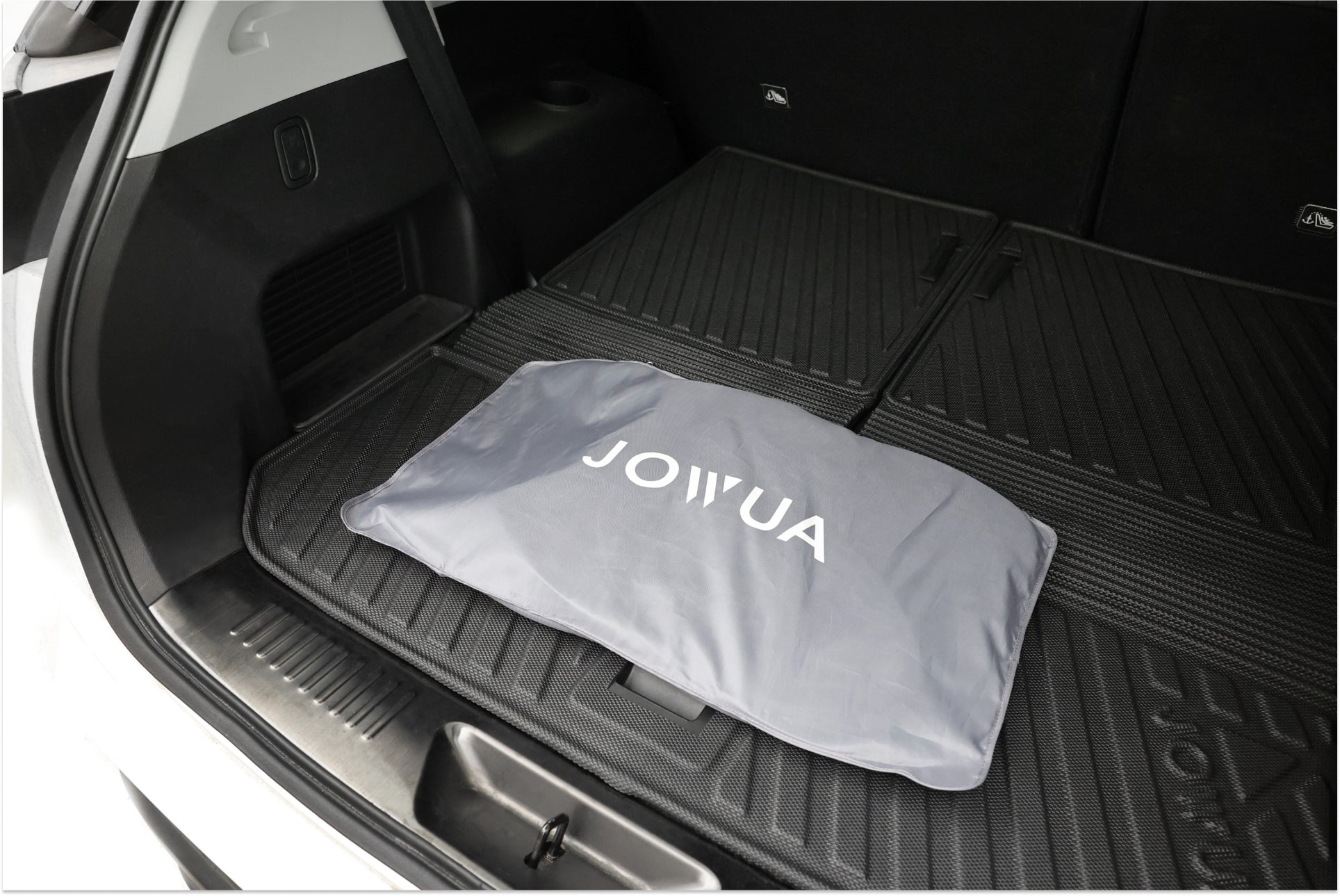 圖中顯示的是 LUXGEN n⁷ 寬敞的後部貨物區域,並配有保護墊。灰色的JOWUA台灣包放在中央,更方便。該墊子經過精心製作,可以無縫適應車輛尺寸。.