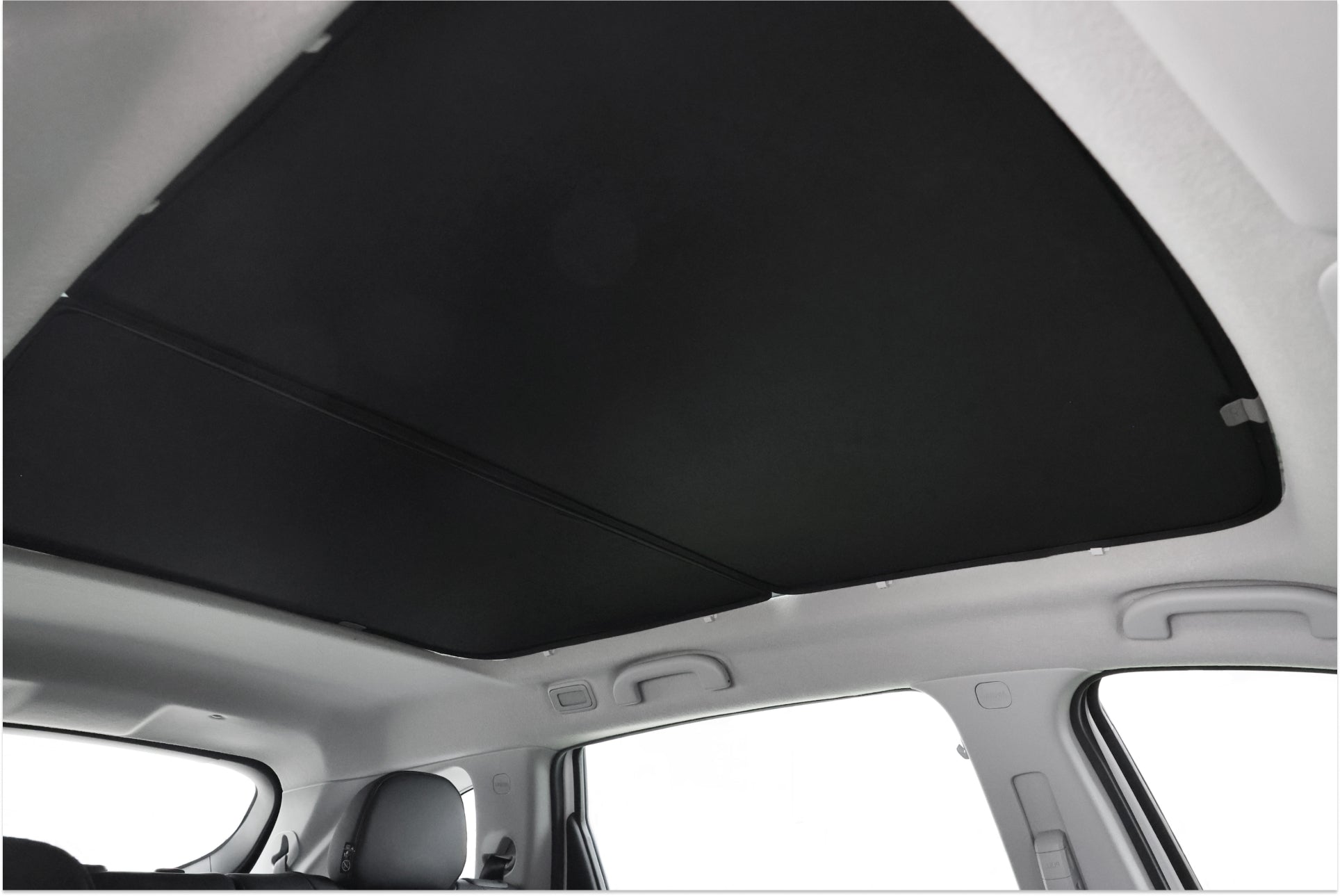 LUXGEN n⁷ 的內部採用由 JOWUA Taiwan 設計的封閉式玻璃車頂遮陽簾。光滑的黑色天花板增強了設計感,可以看到汽車座椅和窗戶。遮陽板與車頂框架平滑貼合,提升了時尚感與舒適度。.