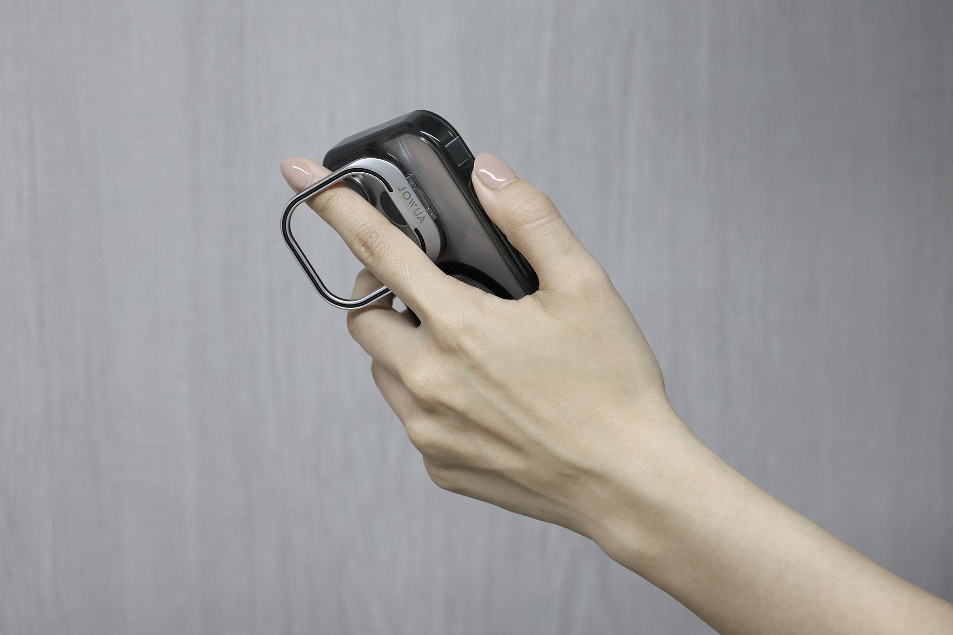 手持黑色 iPhone 的 JOWUA Taiwan MagSafe 透明支架保護殼,sett 在淺灰色背景下,突顯日常使用中的無縫無線充電 for iPhone 15/14/13 系列。.