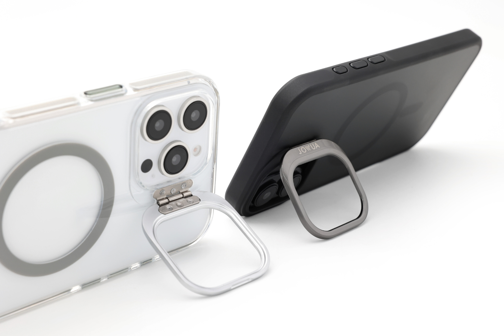 展出的兩款智慧型手機均配備了 JOWUA Taiwan 為 iPhone 16 系列設計的 MagSafe透明支架保護殼+掛繩夾片組。左邊的手機有一個透明外殼,右邊的手機是黑色的,兩款手機都配有指扣支架,方便直立站立。.