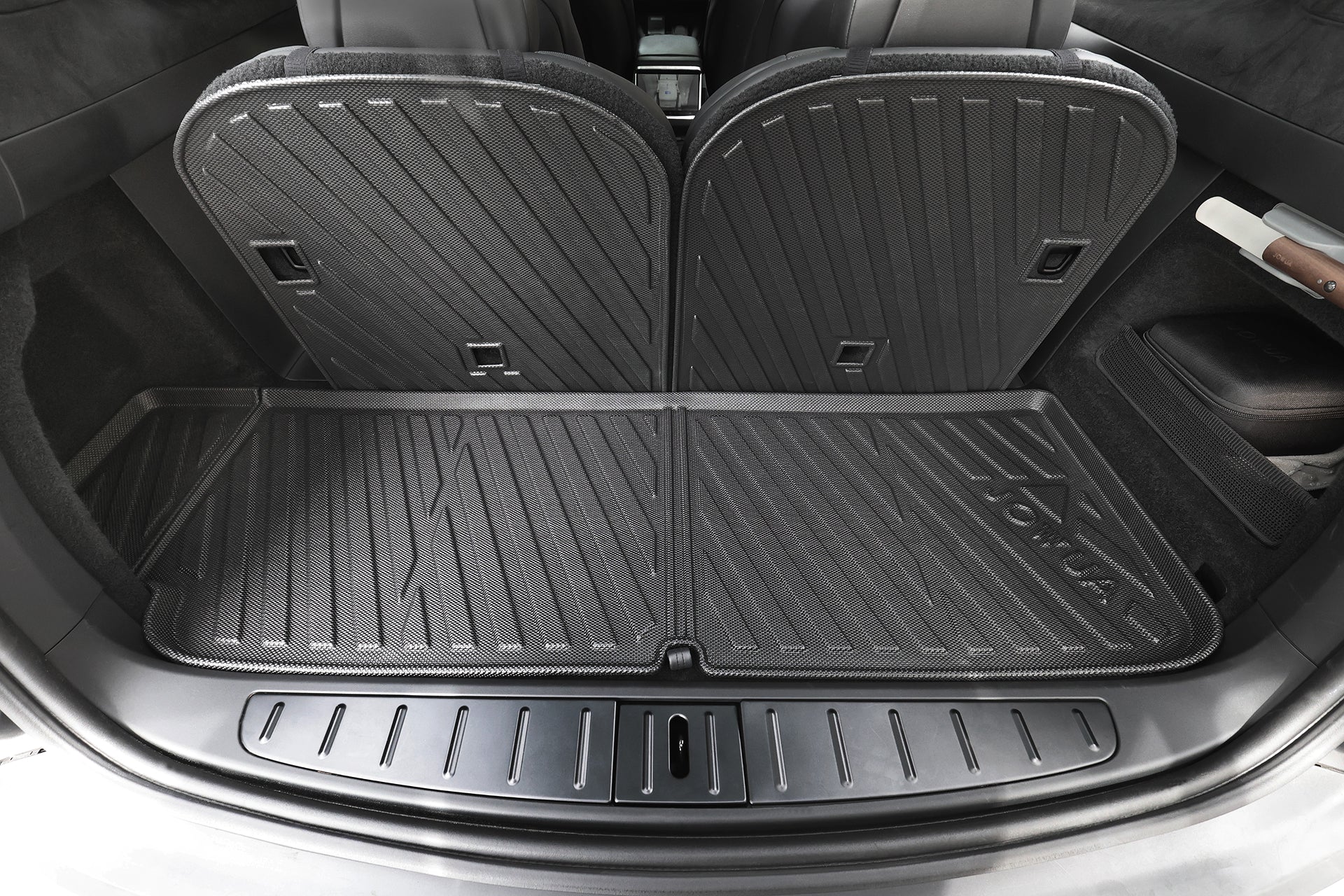 後排座椅直立的車內貨運區特寫,採用 JOWUA Taiwan 立體防水行李廂墊 (Model X 2025+/2021-2024),客製化的黑色墊子上有紋理圖案,提供防水防塵保護。.
