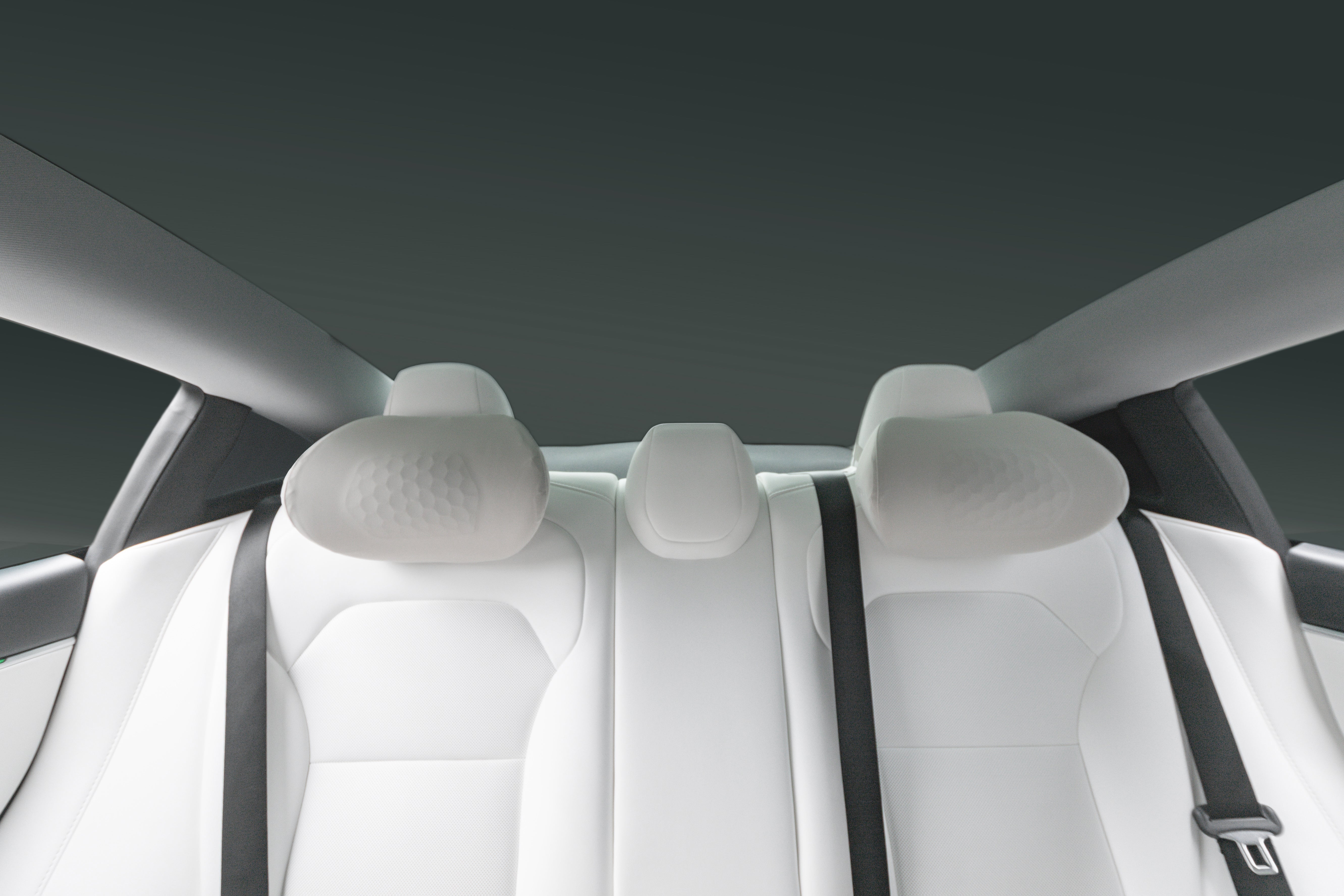現代車輛後座的後視圖,白色真皮襯裡,以 JOWUA Taiwan 車用頭枕(兩入/一入)和兩條黑色安全帶為特色,背景為深色的簡約風格。.