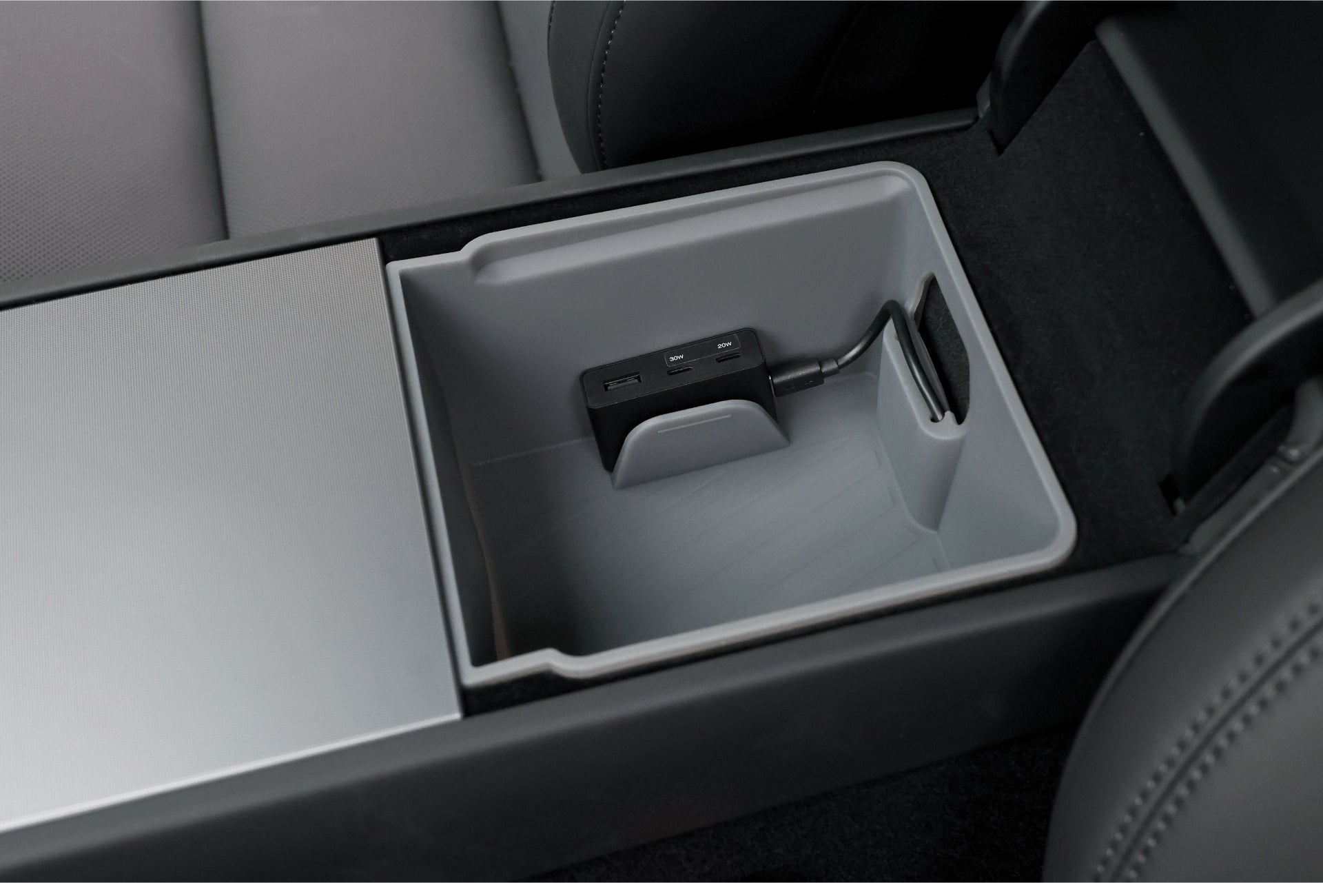 JOWUA Taiwan 的 Power HUB 是一個汽車中央控制台存儲隔間,帶有用於高速充電的 USB 集線器。它包含多個端口,例如 USB-C 電源轉換器,並且周圍環繞著帶有滑動蓋的黑色座椅。.