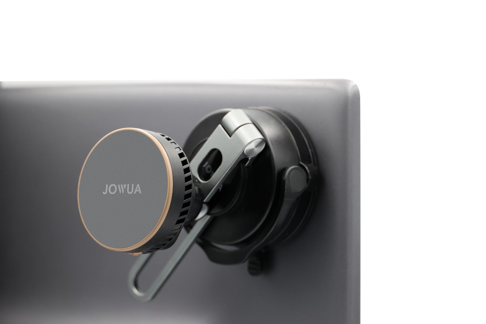 台灣 JOWUA 的 Qi2 製冷六維隱藏車架 (MagSafe 款) 圓形裝置特寫,搭配 MagSafe 磁吸,使用黑色金屬夾鉗固定在顯示器背面,背景為純白背景。.