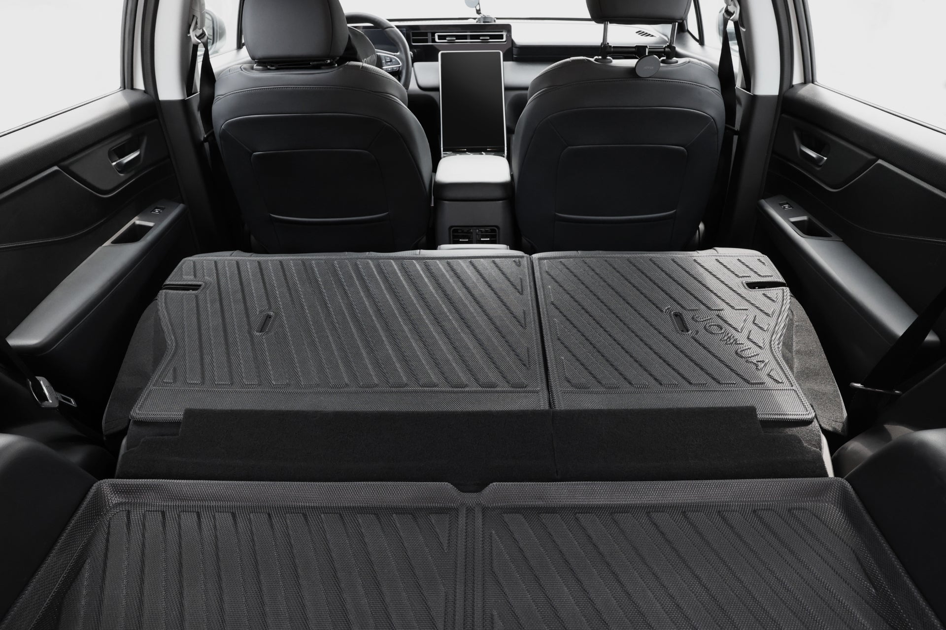 從車尾俯瞰,可看到後座摺疊放平,形成延伸的貨運空間,並覆蓋 JOWUA Taiwan 立體防水行李廂墊+椅背墊組合 (LUXGEN n⁷ 5人座),前方為前座與中控台。.