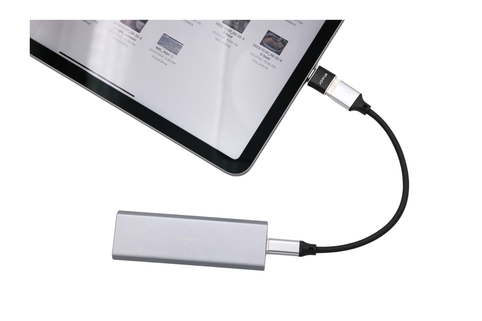 平板電腦透過 JOWUA 台灣哨兵讀組 (USB-A 轉 Type-C 和 Lightning) 連接到外部設備,具有 OTG 功能。螢幕以網格形式顯示影像縮圖,矩形裝置具有光滑的金屬外觀。.