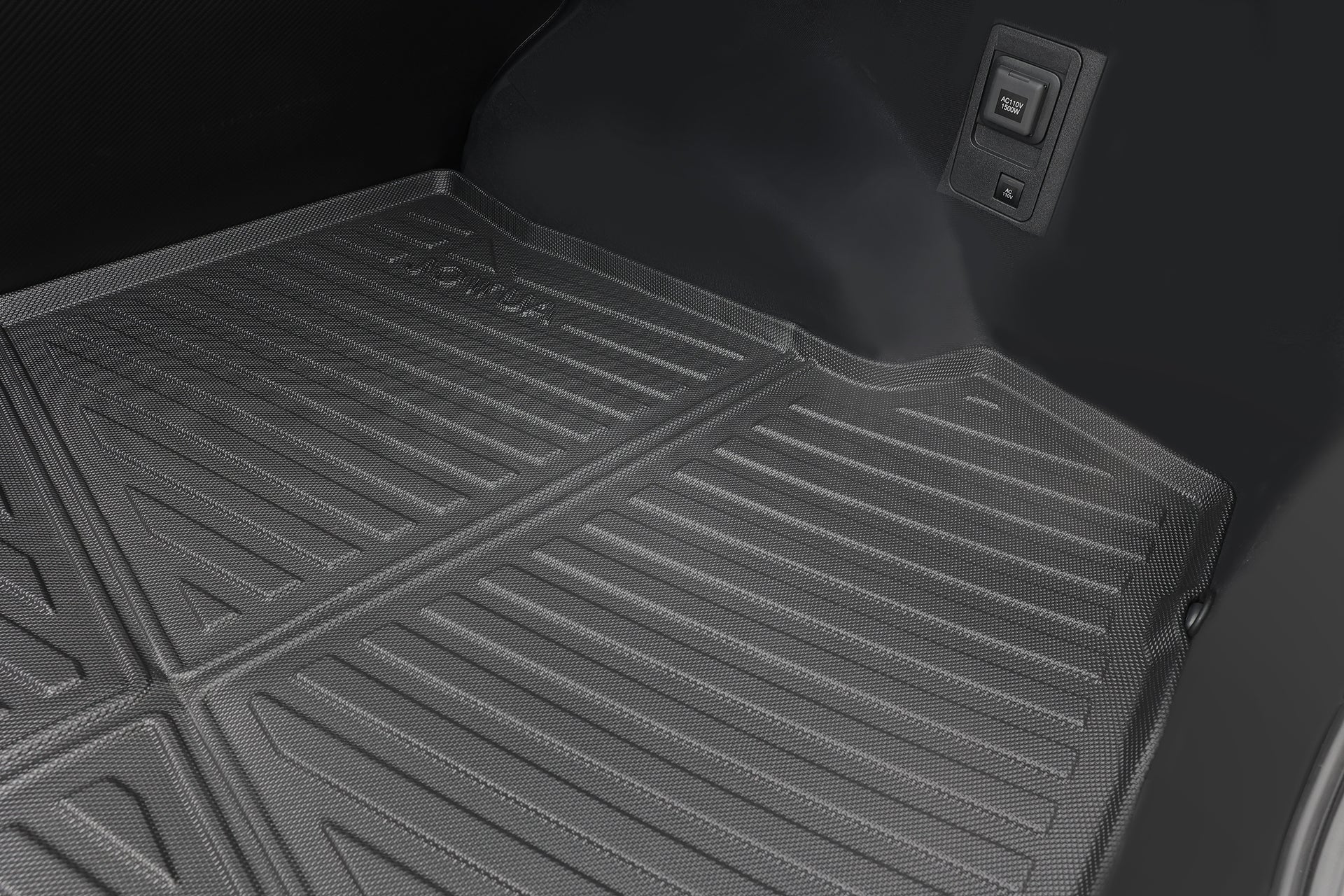 這是 JOWUA 台灣 立體防水行李箱墊(Toyota bZ4X)在後車廂區域的特寫畫面,其表面具有模壓凹槽、浮雕標誌,以及加厚耐磨 3D 防水設計。側板處可見兩個電源插座或開關。.