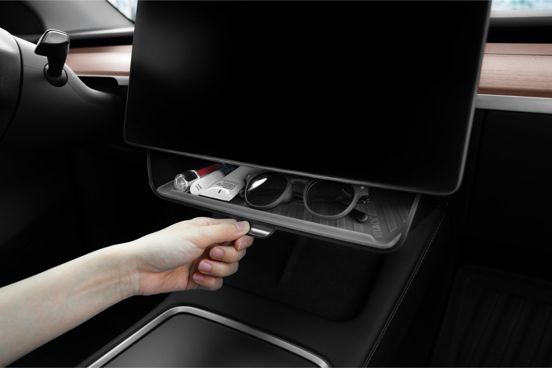 用手打開台灣 JOWUA 的一幕瞭然【Model Y 煥新版|交車禮包】under a Tesla 觸控螢幕,露出井井有條的配件。時尚的木質飾邊與簡約設計,讓太陽眼鏡、鑰匙等車用配件整齊又方便拿取。.