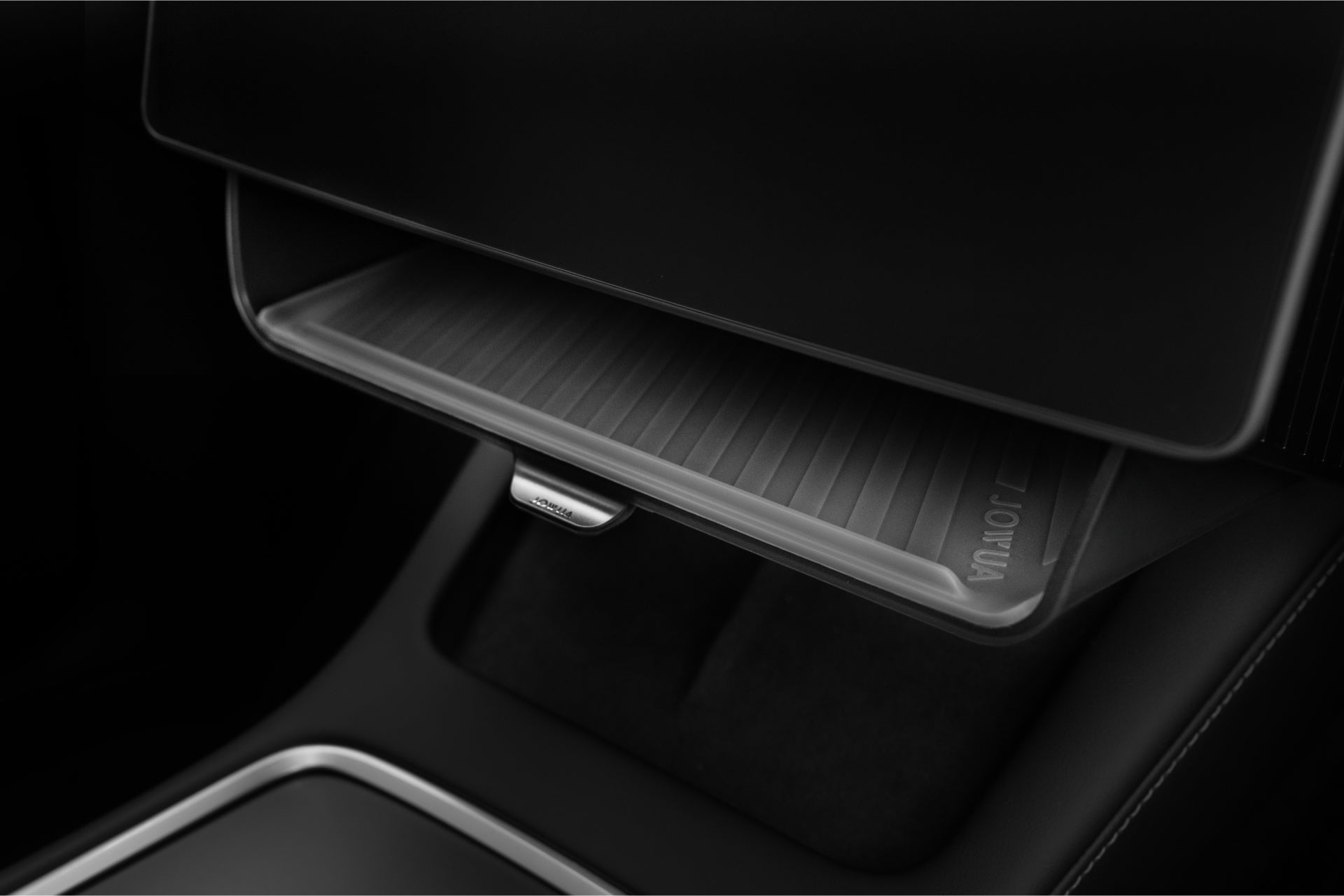在現代汽車中,一個打開的手套箱特寫,展示了 JOWUA Taiwan 一幕瞭然【Model Y 煥新版|交車禮包】,一個纖薄的脊狀文件夾,非常適合 Tesla 車用配件,夾在時尚的黑色和灰色儀表板細節中。.