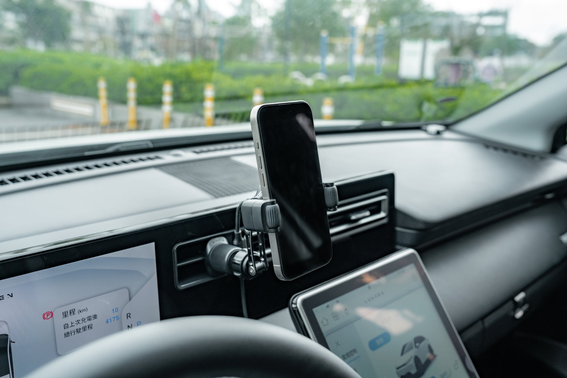 JOWUA Taiwan 出風口車架Qi2(滾輪款)可將智慧型手機放置在儀錶板上,並進行 360° 調節,同時顯示地圖。同時,汽車的觸控螢幕提供導航詳細信息,外面鬱鬱蔥蔥的綠色植物增強了駕駛的寧靜。.