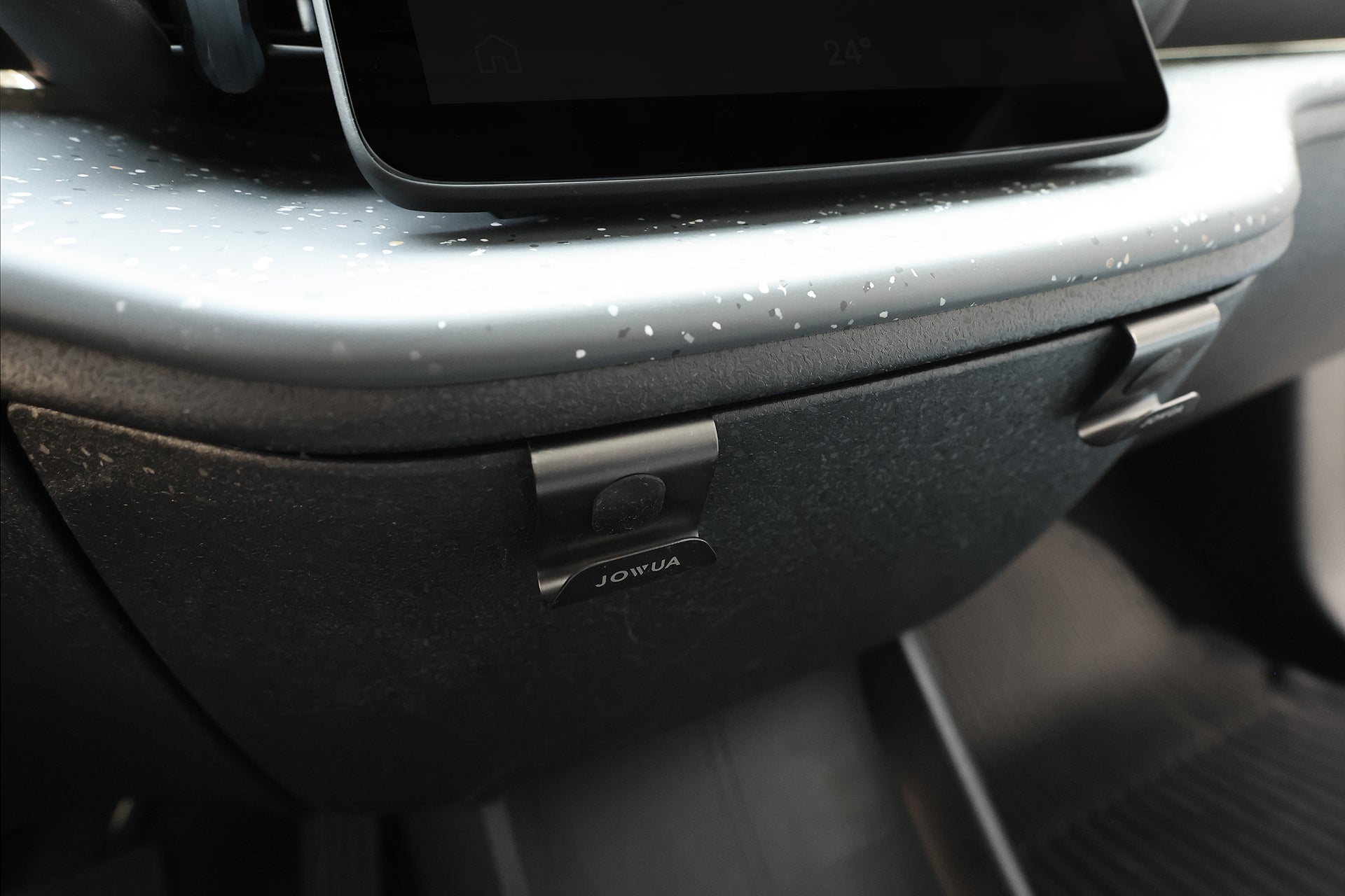 汽車手套箱特寫,附有標示 JOIN 的黑色夾子;可見部分觸控螢幕及 JOWUA Taiwan 手套箱掛鉤 (適用於 Model S/X、Model 3/Y煥新版及 Volvo EX30),非常適合整理車用收納。.