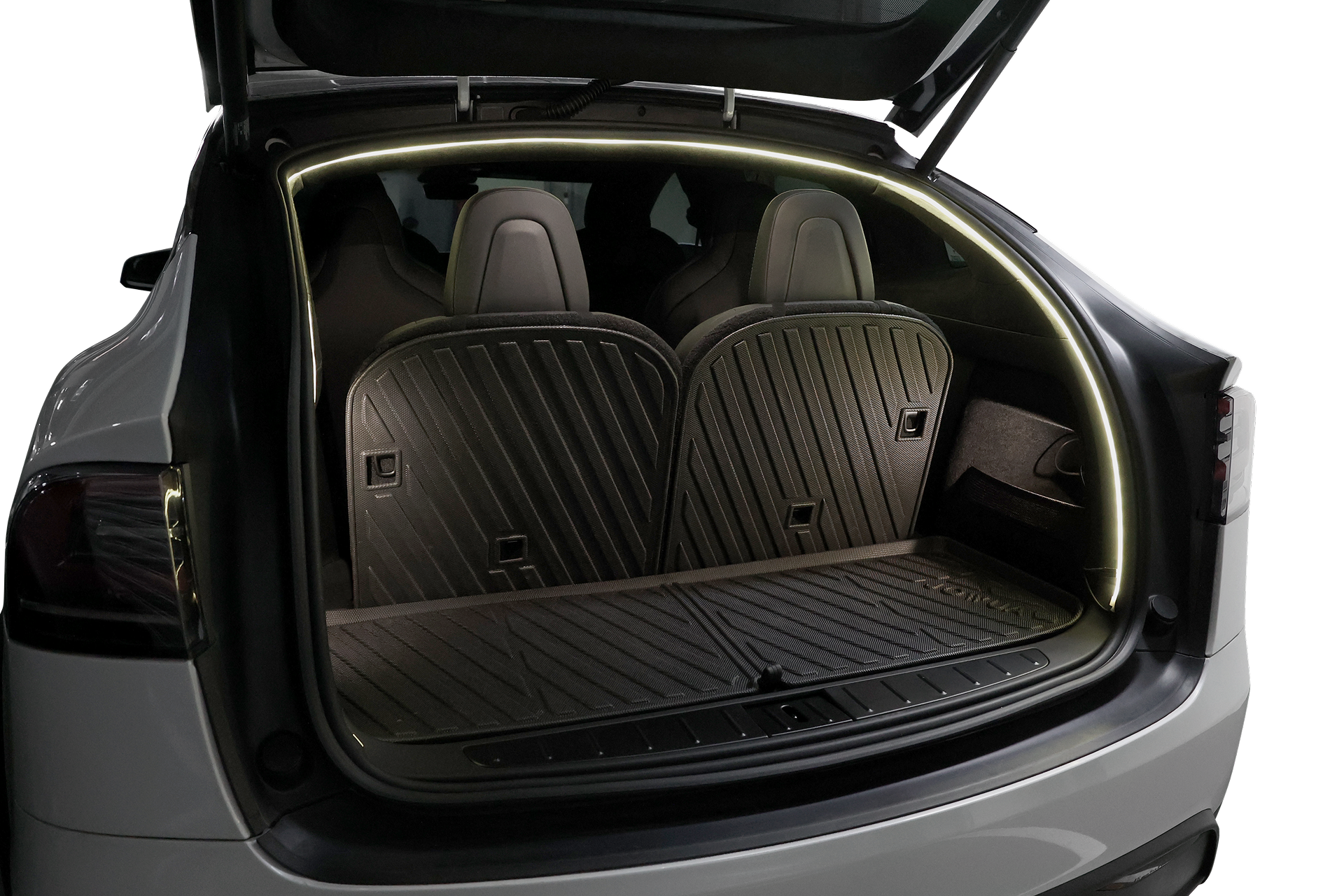 一輛後座直立的白色汽車,開啟的後車廂內有黑色的輪廓地墊,以及照亮空間的 JOWUA Taiwan 後車廂氣氛燈|真言套索 (Model X) LED 燈條。背景為純白。.