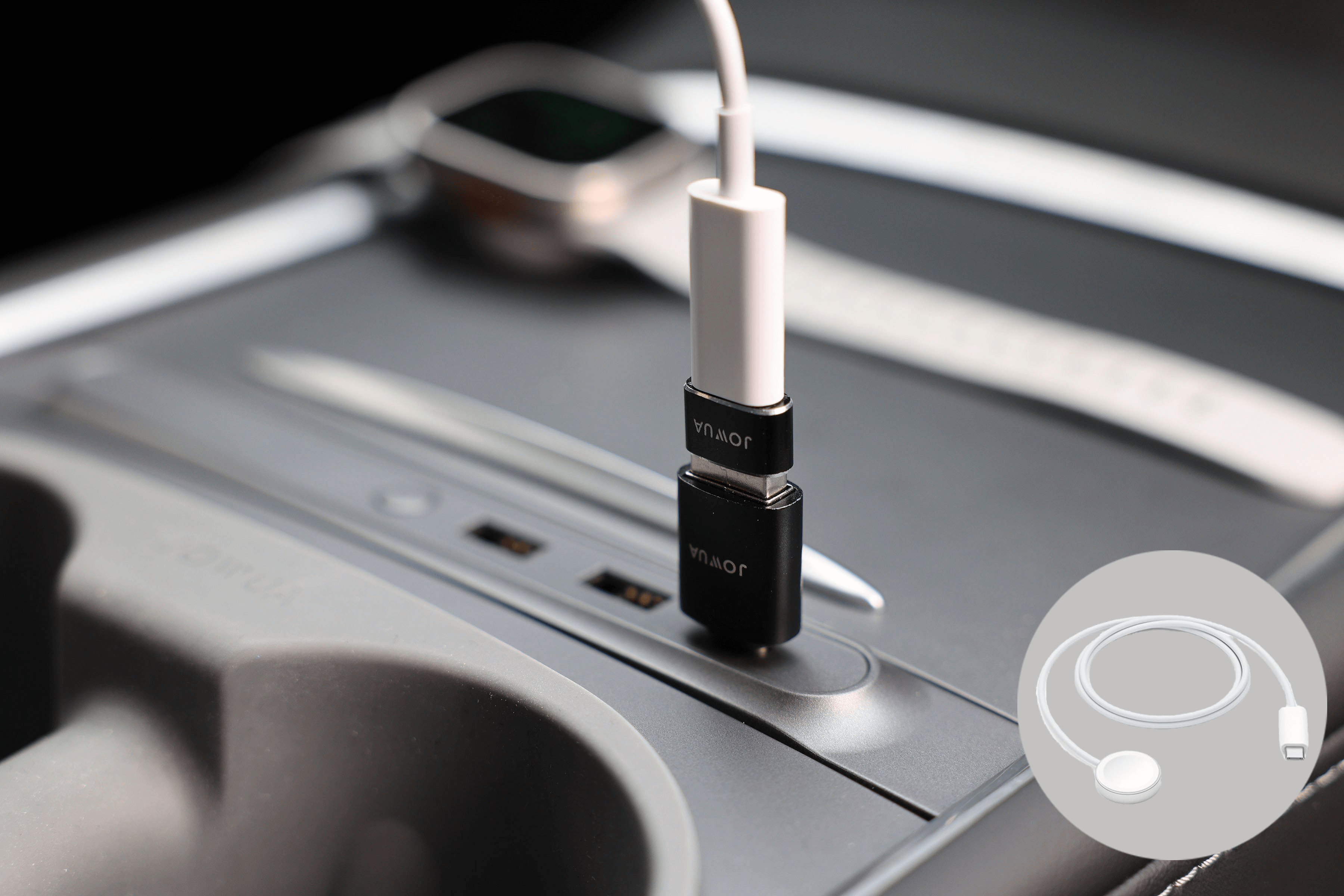 汽車中央控制台連接埠處有一個 JOWUA 台灣 Apple Watch 充電套件,配有 USB-C 轉接器和白色充電線。背景中可以看到一條 Apple Watch 錶帶,角落處有一個圓形圖標,顯示有捲曲的電纜和插頭。.