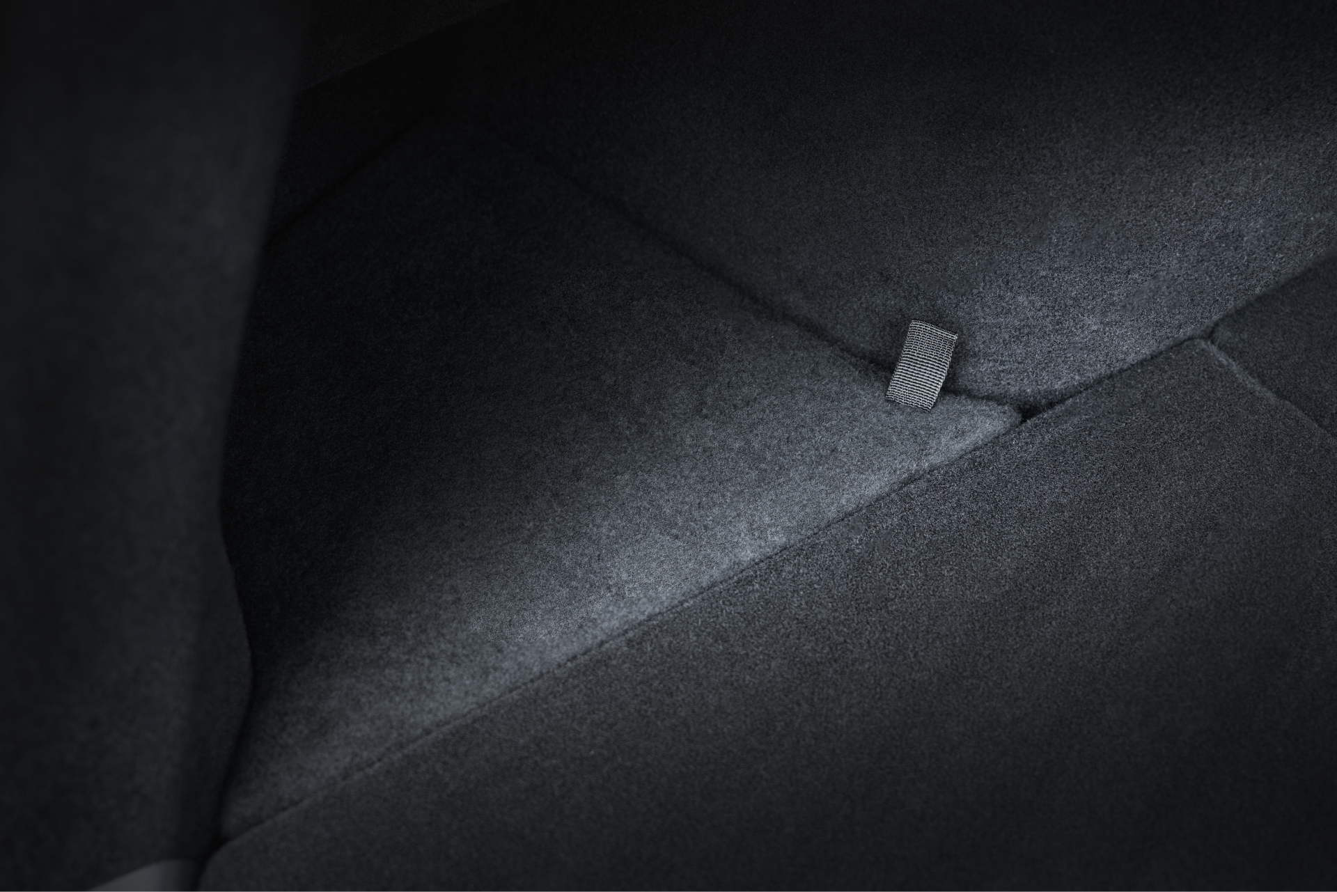 JOWUA 台灣後行李廂儲物組(型號 Y 2021-2024)的特寫,採用時尚的深色內飾、單個 ISOFIX 錨片和耐用的矽膠材質裝飾,在柔和的燈光下增添舒適感和時尚感。.