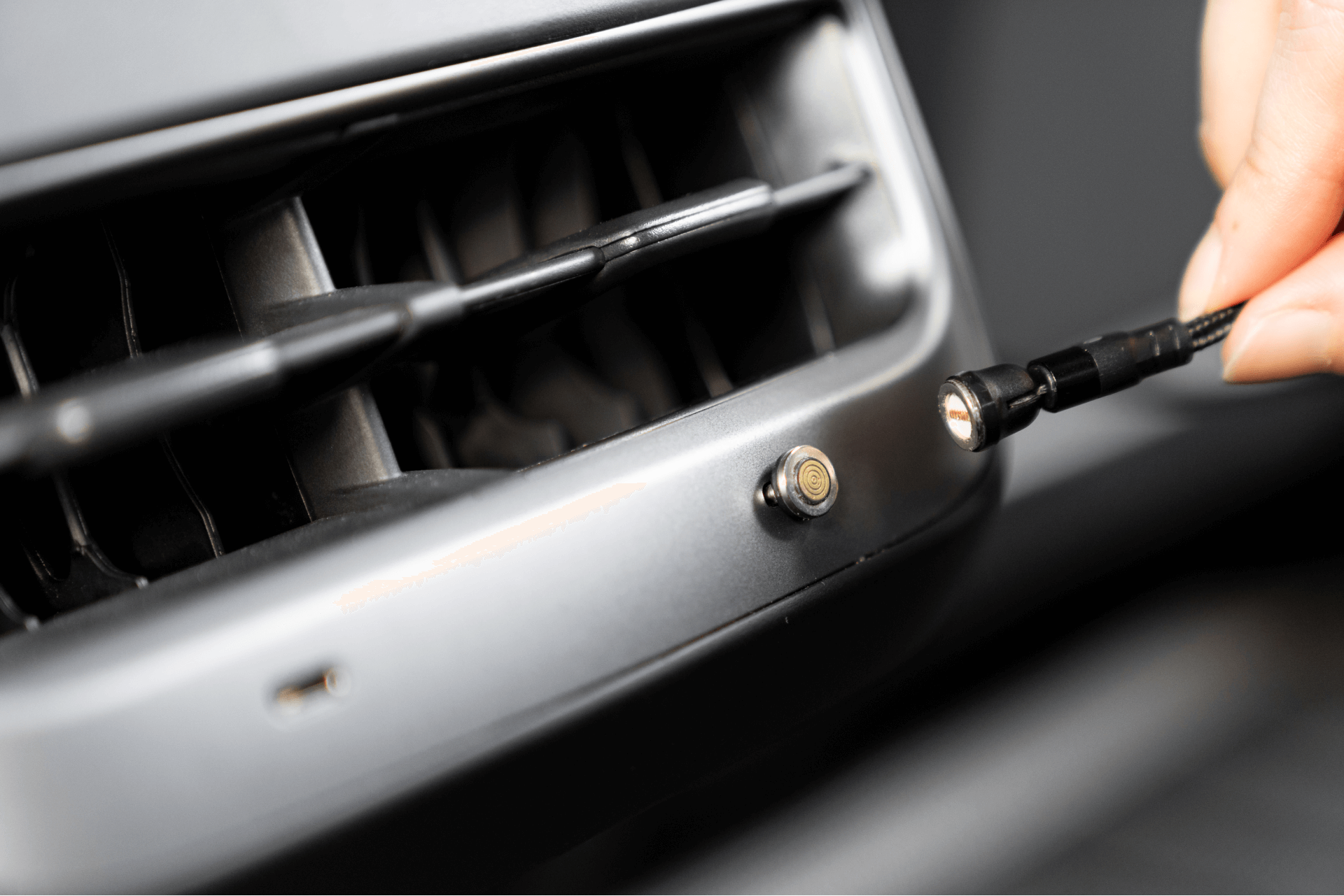 一手將JOWUA台灣USB-C車用磁吸線連接至Model 3中控上的圓形磁性手機支架,靠近灰色儀表板上的通風口,實現高效的USB-C PD快充。.